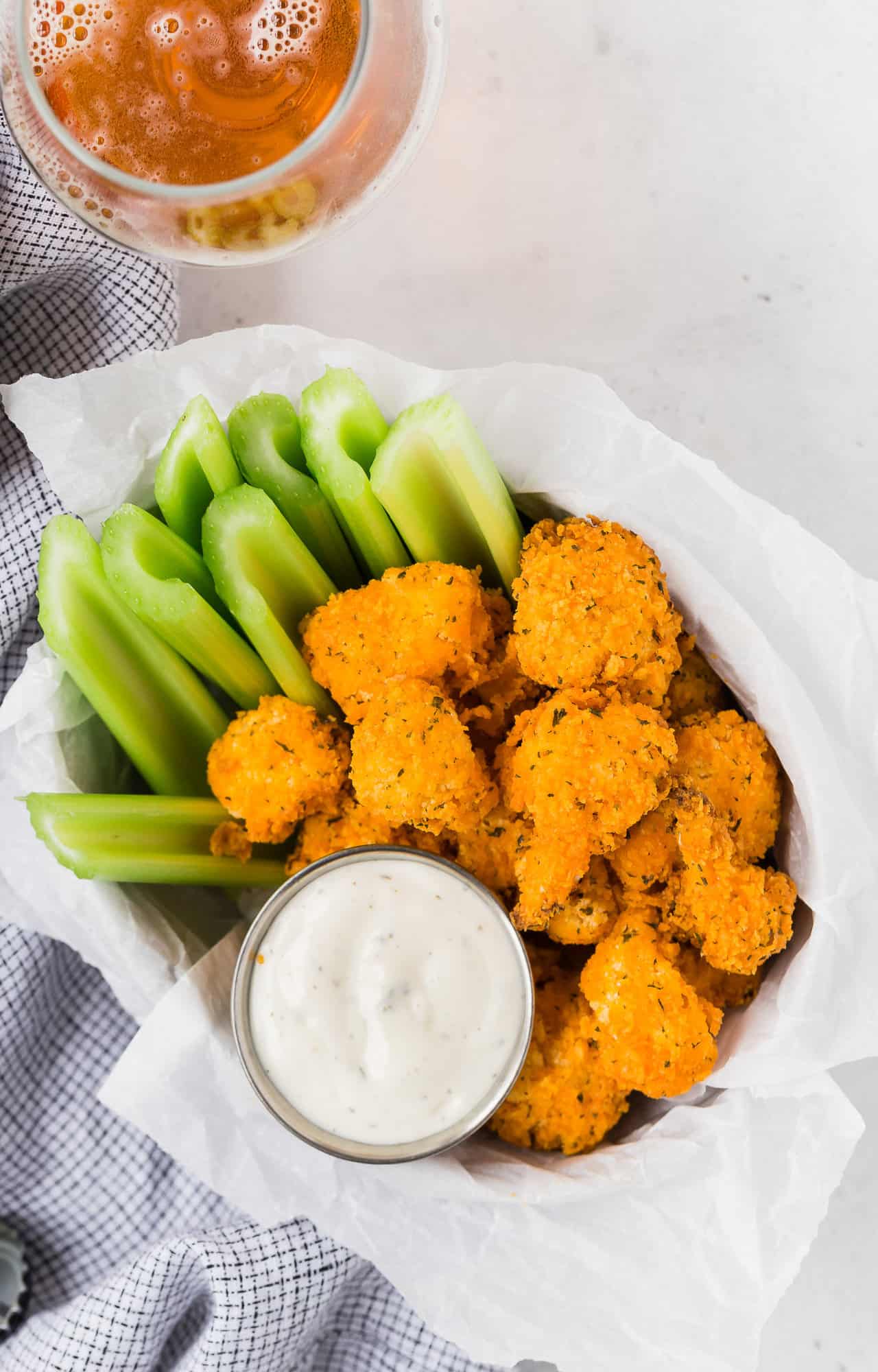 Overhead view of cauliflower wings, celery, and dip.