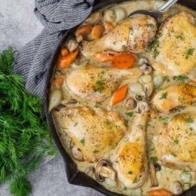 Chicken fricassee in a black skillet.