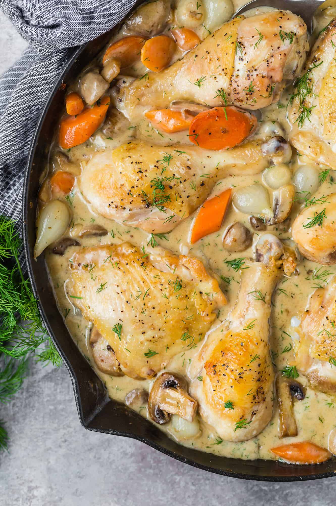 Chicken fricassee in a black skillet.