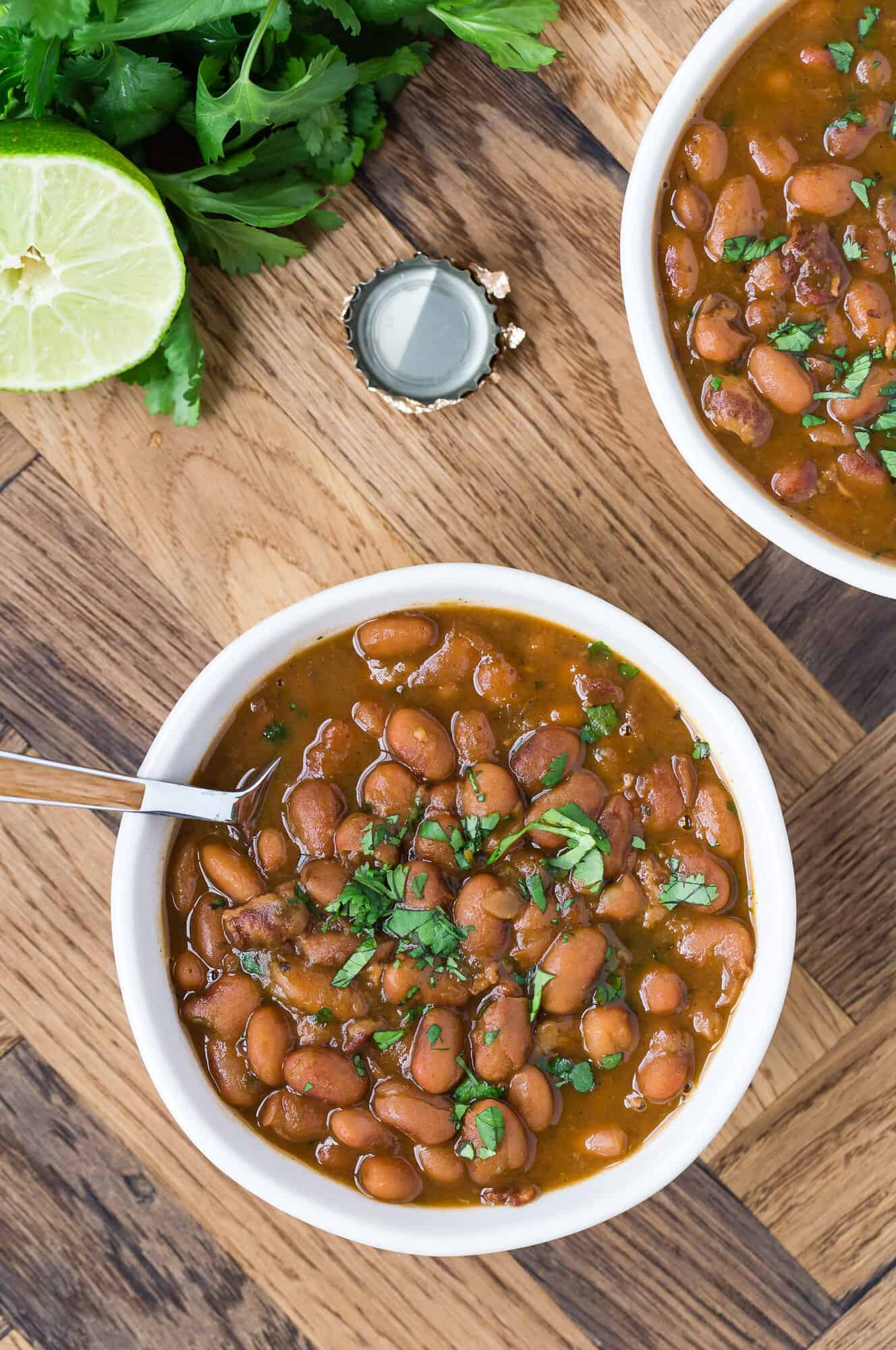 Two bowls of frijoles borrachos, garnished with cilantro.