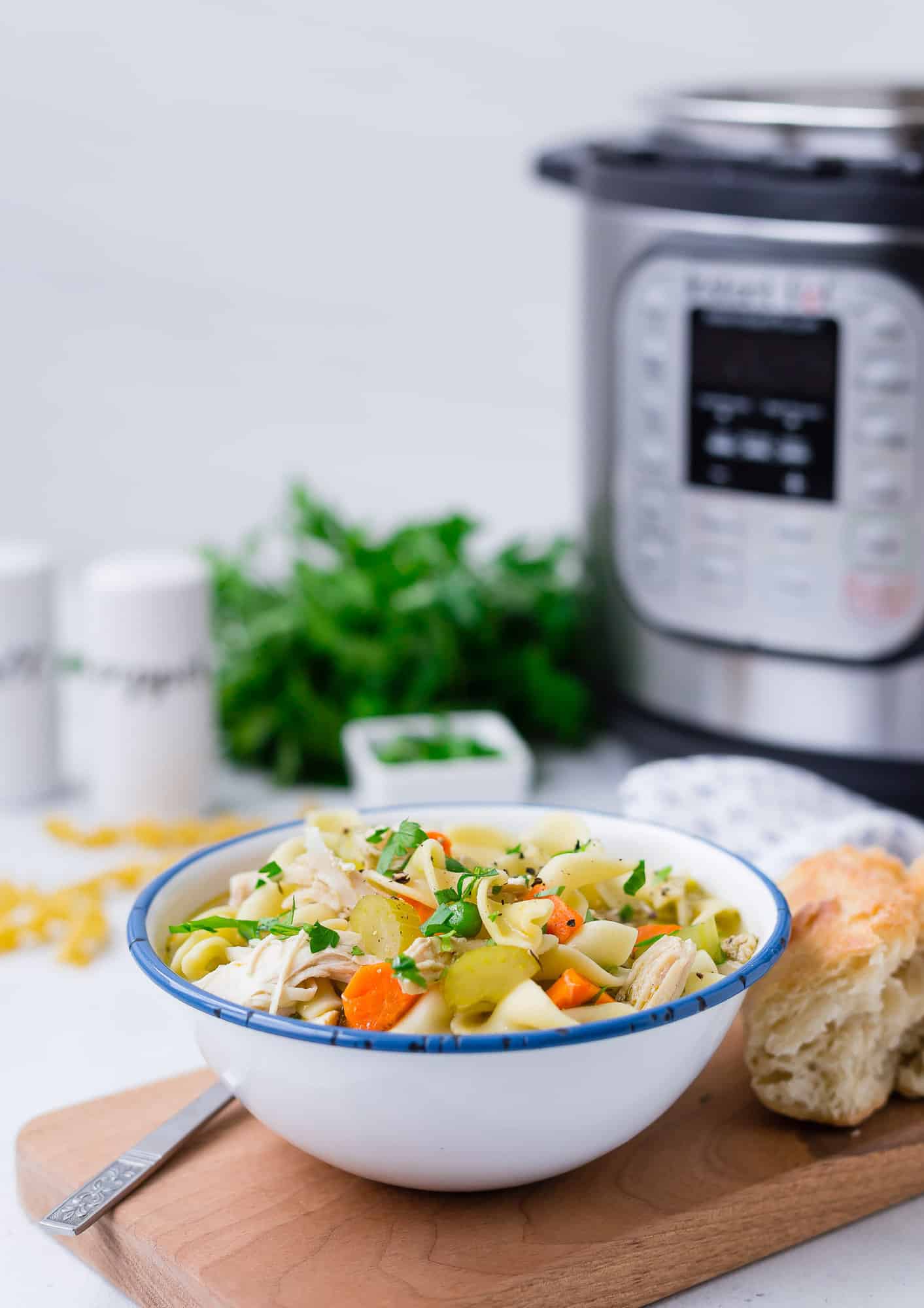 Chicken noodle soup in front of an Instant Pot.