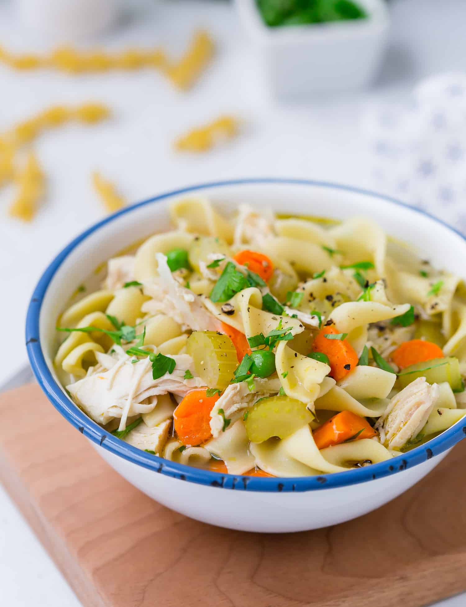 Chicken noodle soup in blue and white bowl.