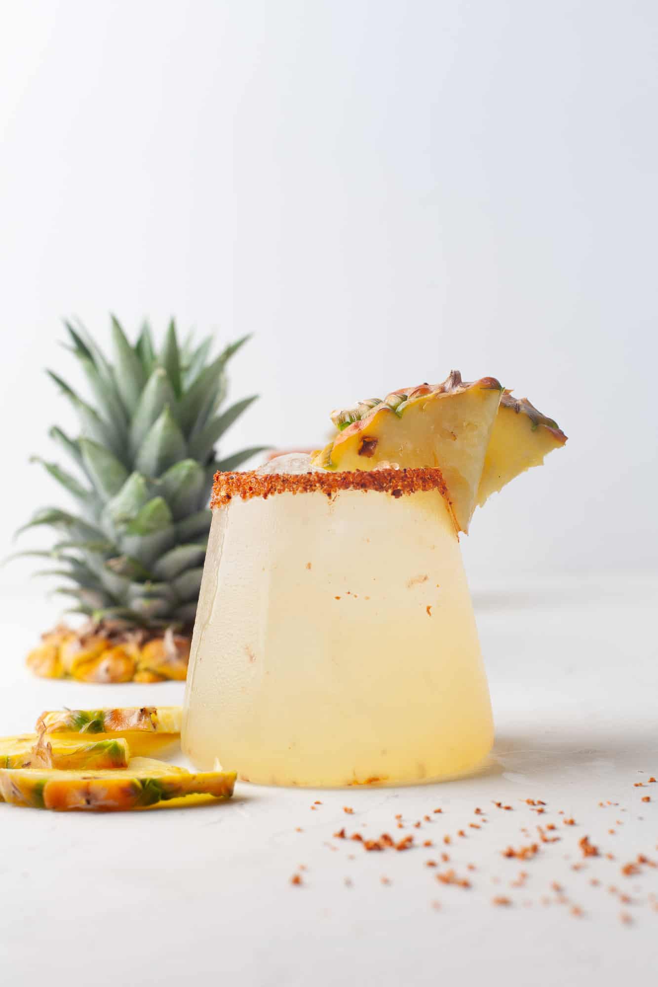 Pineapple margarita with pineapple top in background.