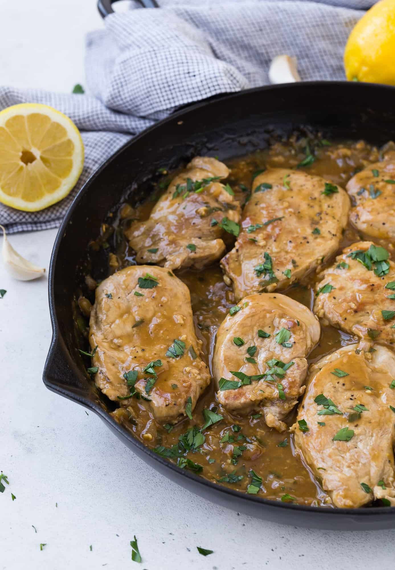 Pork with lemon garlic sauce garnished with parsley.