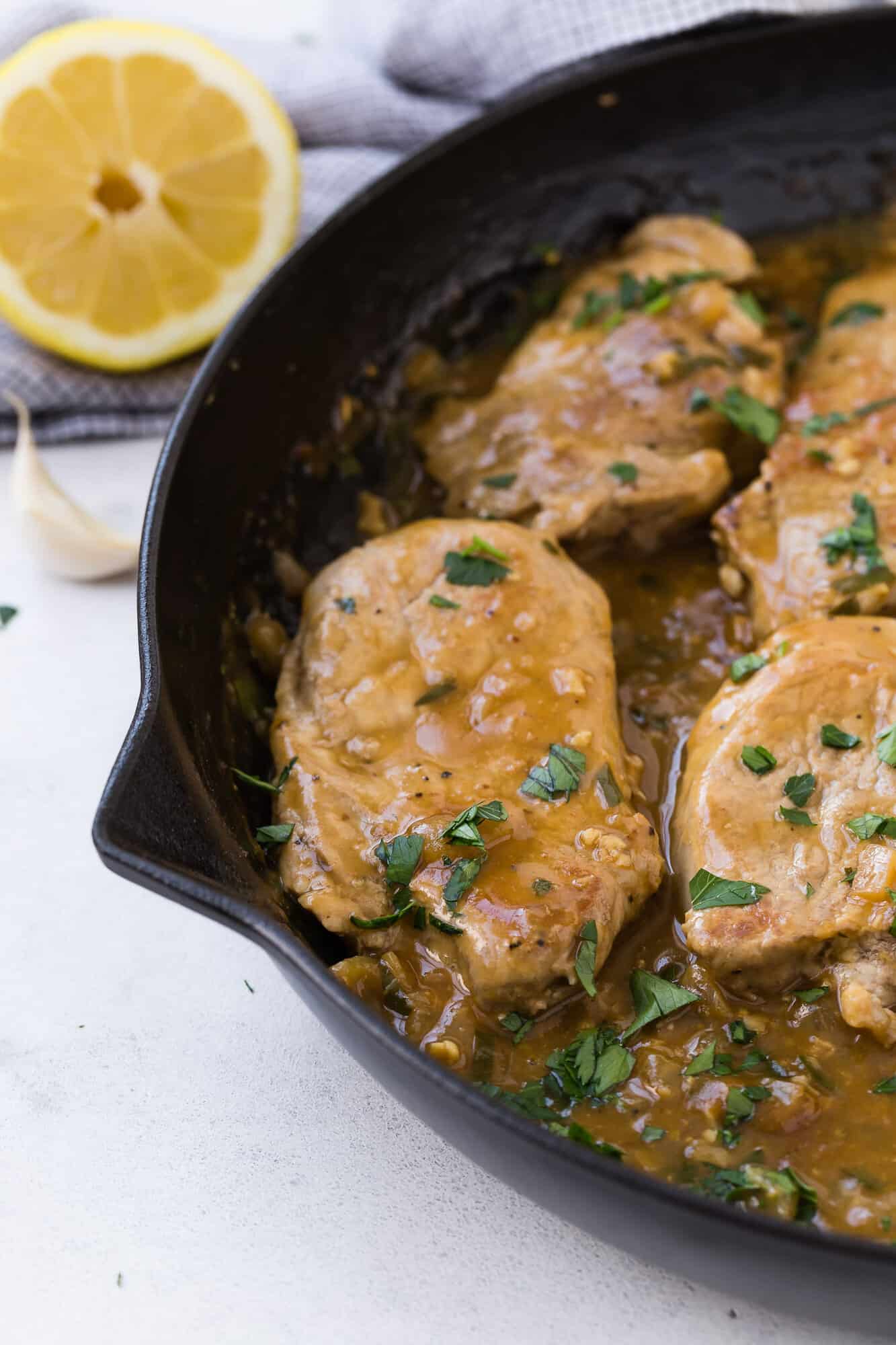 Pork medallions with sauce and parsley.