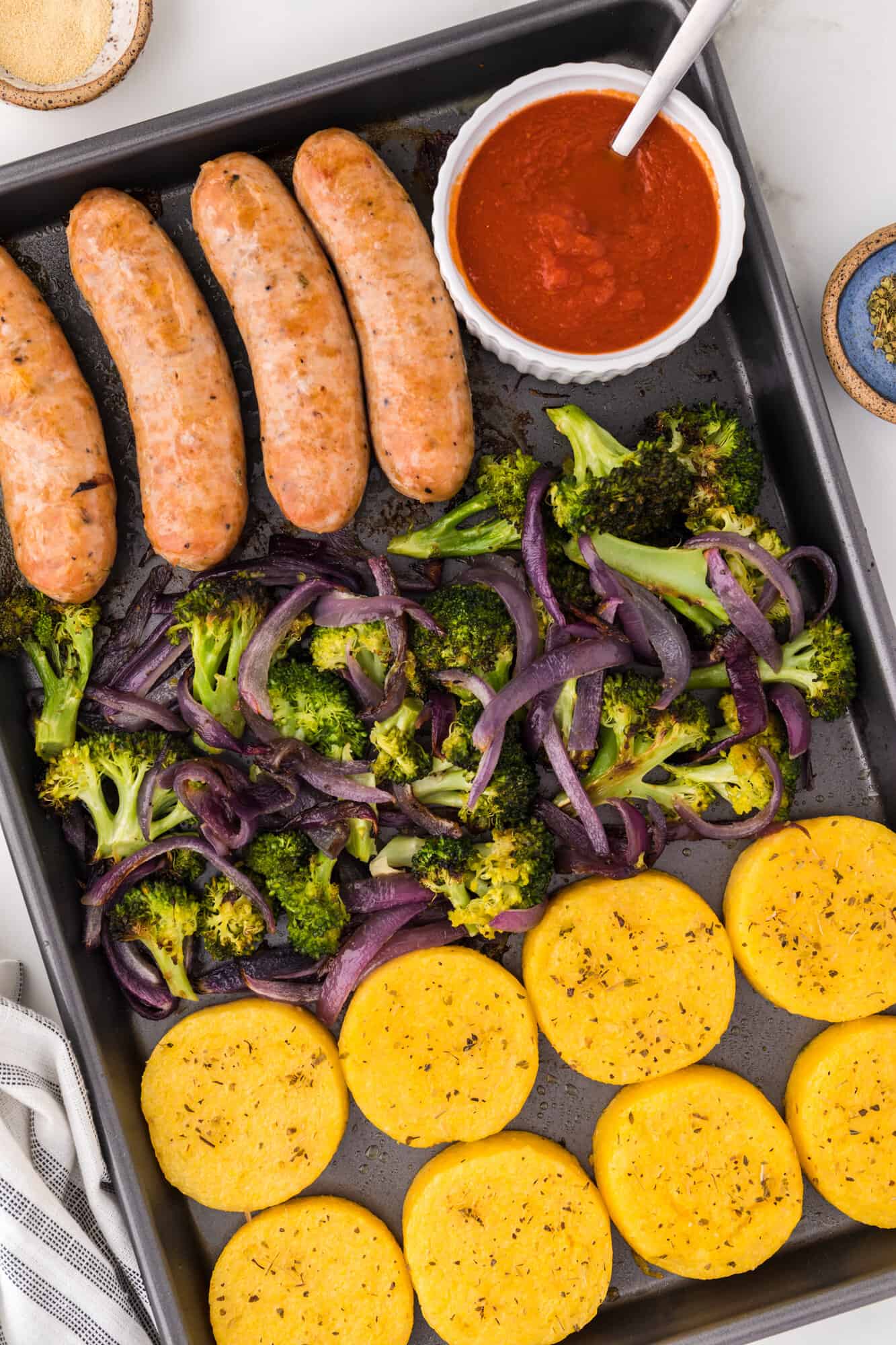 Sausage, broccoli, and polenta on a sheet pan.