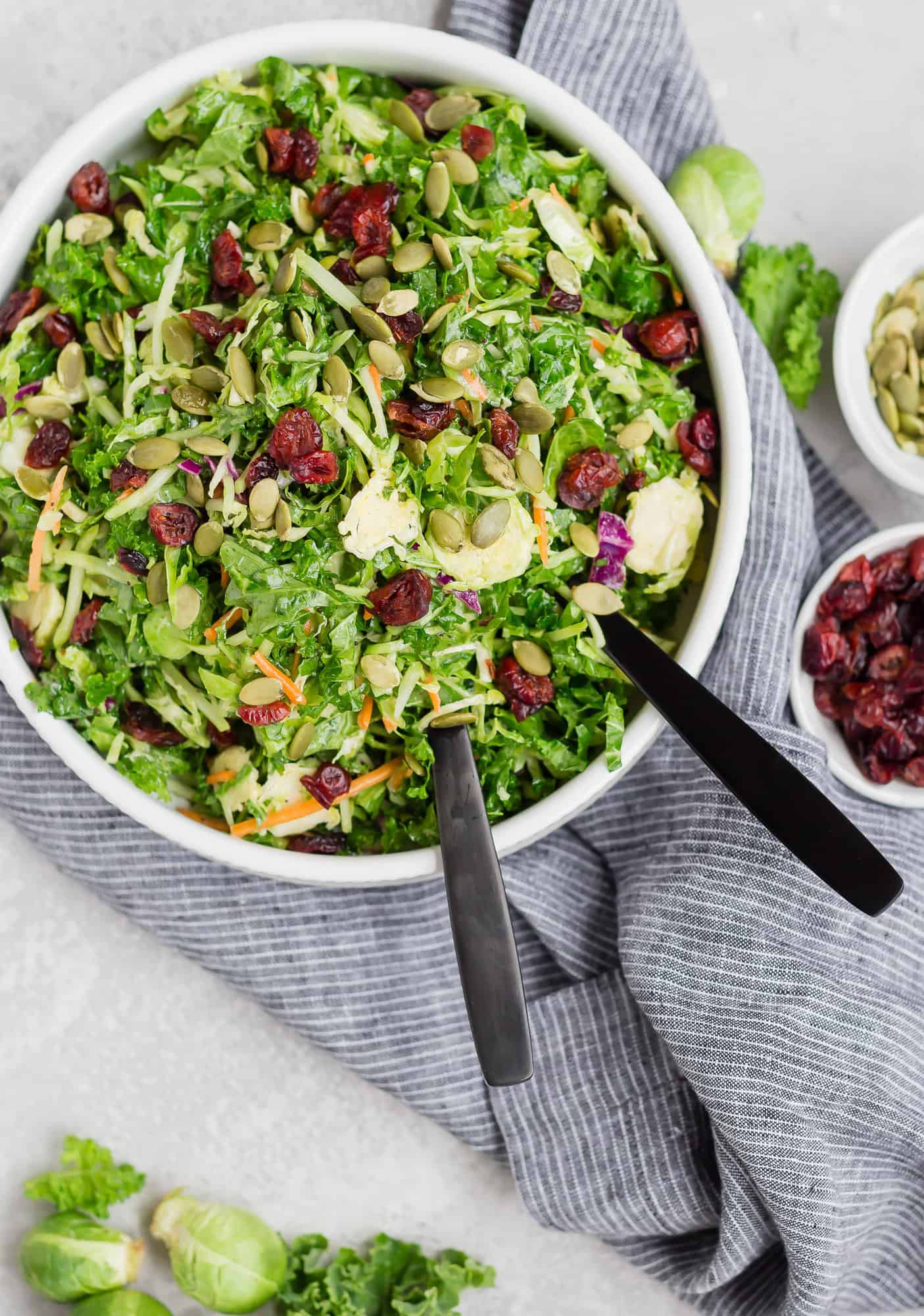 Salad in large bowl with toppings in small bowls next to it.