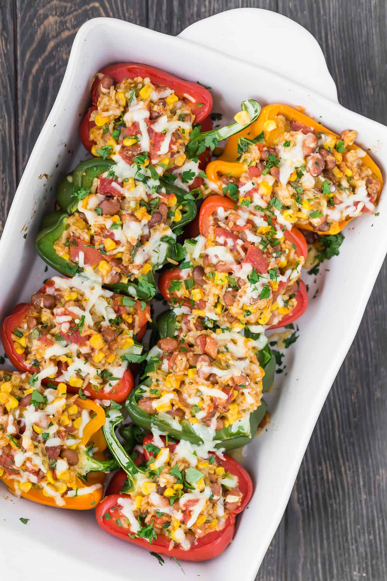 Stuffed vegetarian peppers in baking dish.