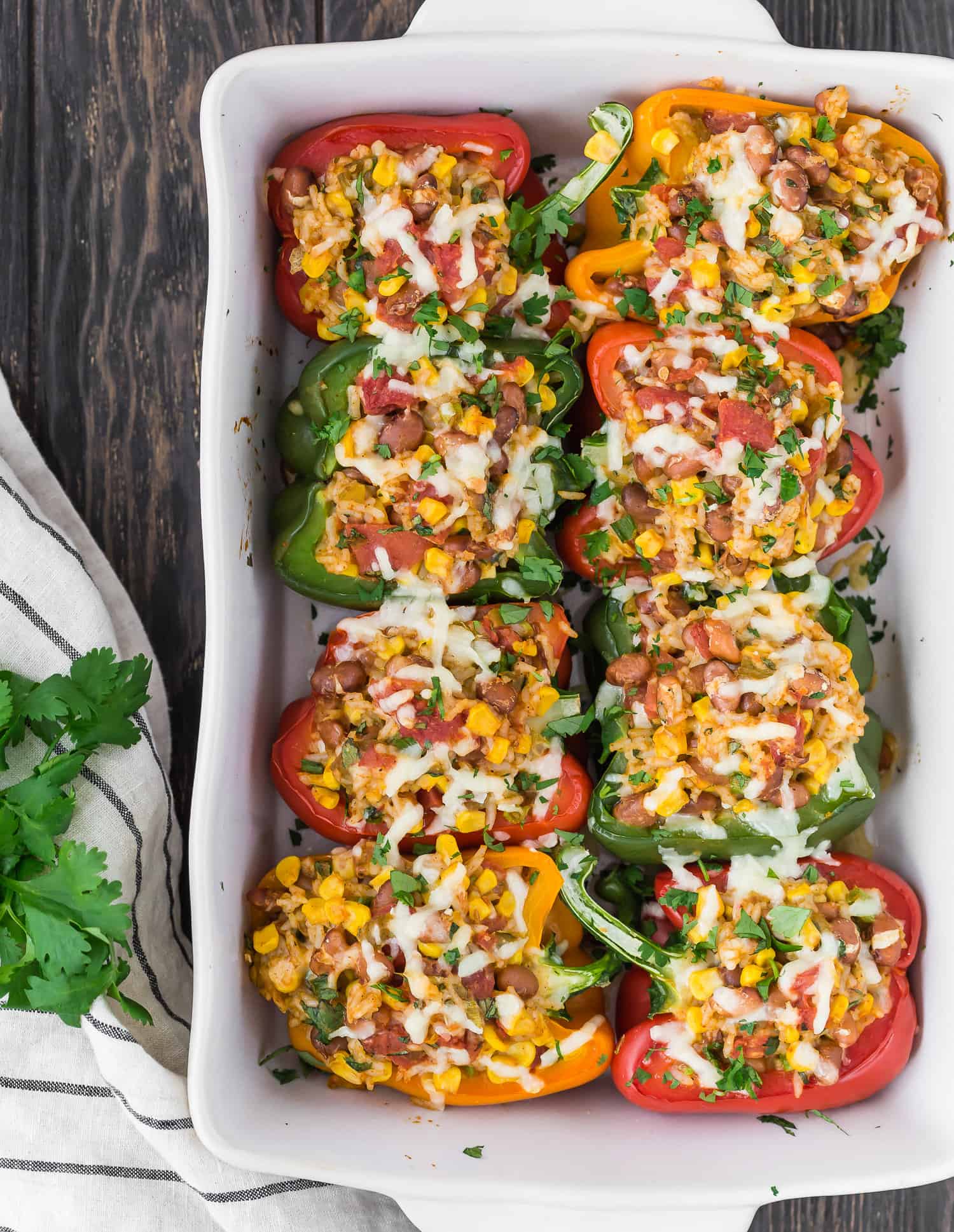 Eight stuffed peppers in white casserole dish.