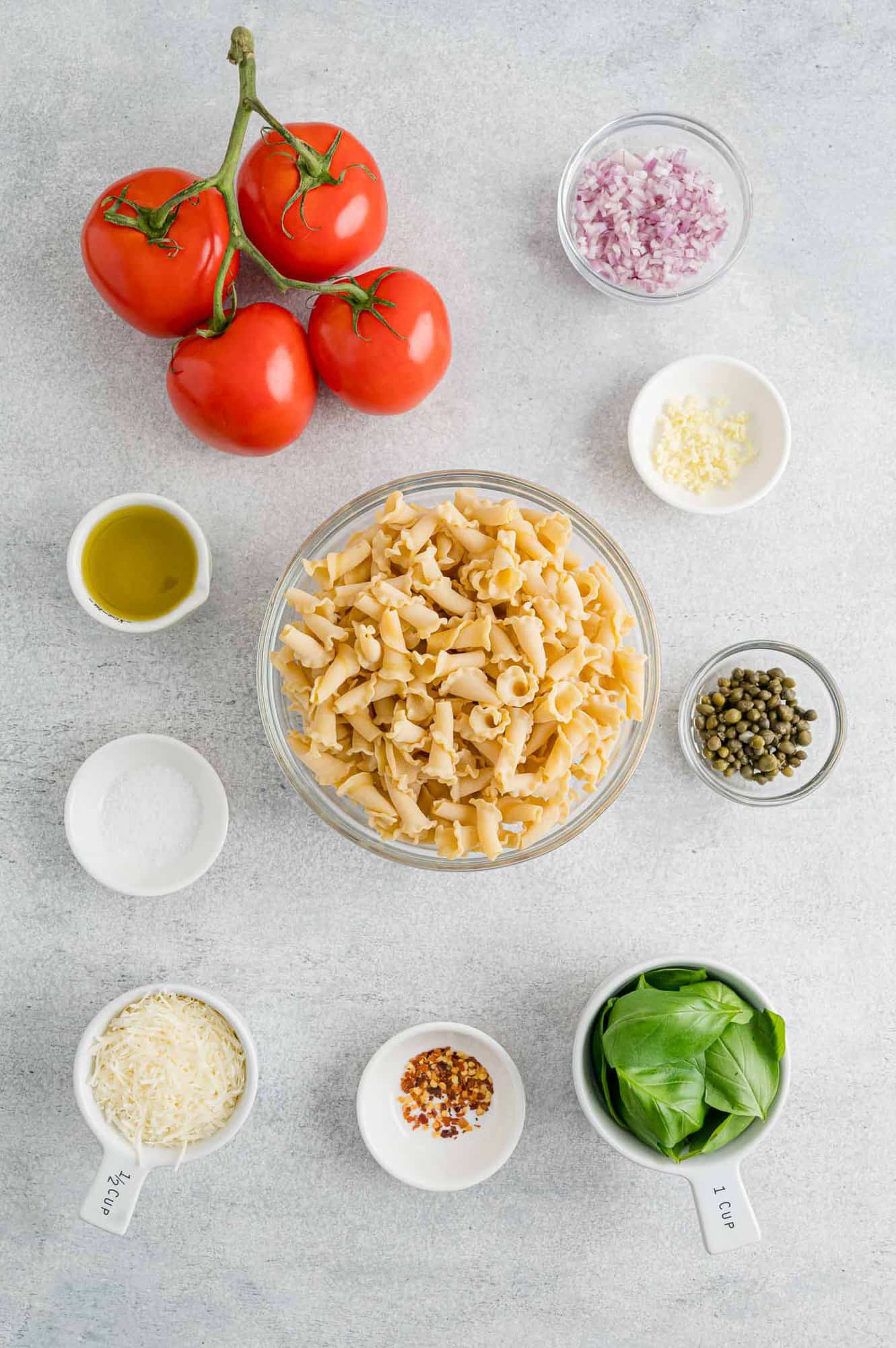 This fresh tomato pasta recipe is the perfect weeknight meal! Made with ripe tomatoes, aromatic basil, garlic, chili flakes, and parmesan. The ingredients for fresh tomato pasta with basil.