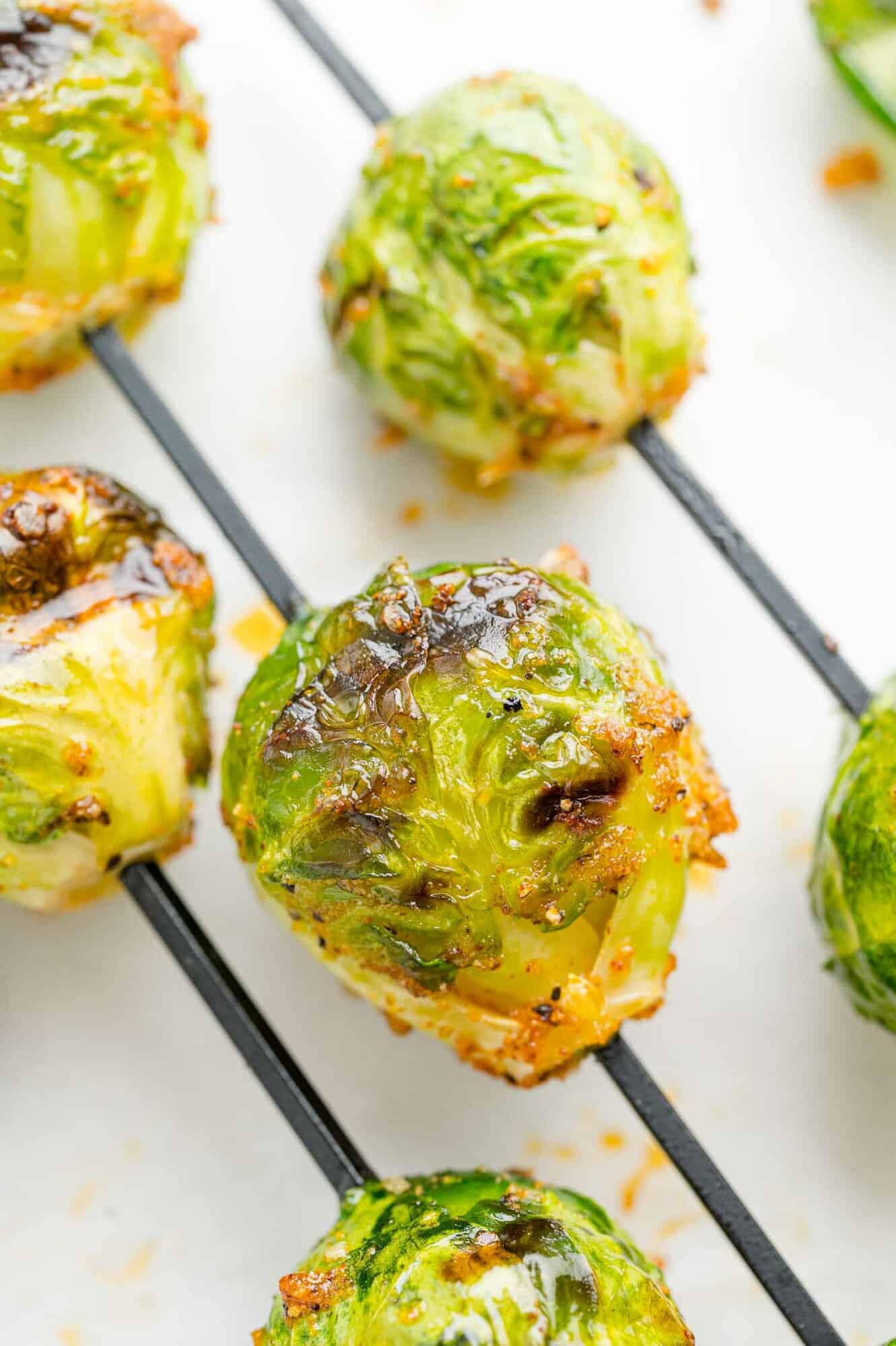 Close up of assorted grilled Brussels sprouts skewers.