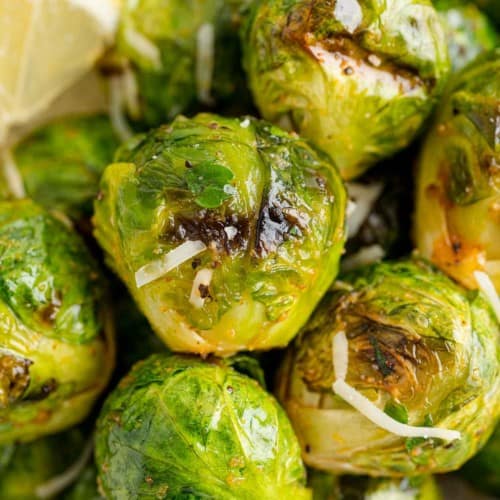 Close up of grilled Brussels sprouts tossed in lemon juice and grated parmesan.