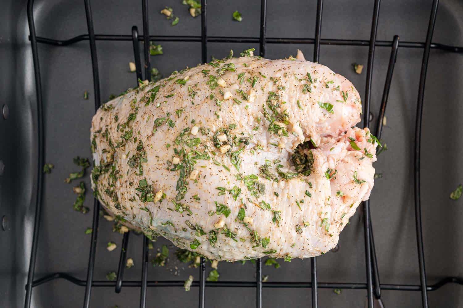 Turkey breast, not yet cooked, rubbed with herbs.