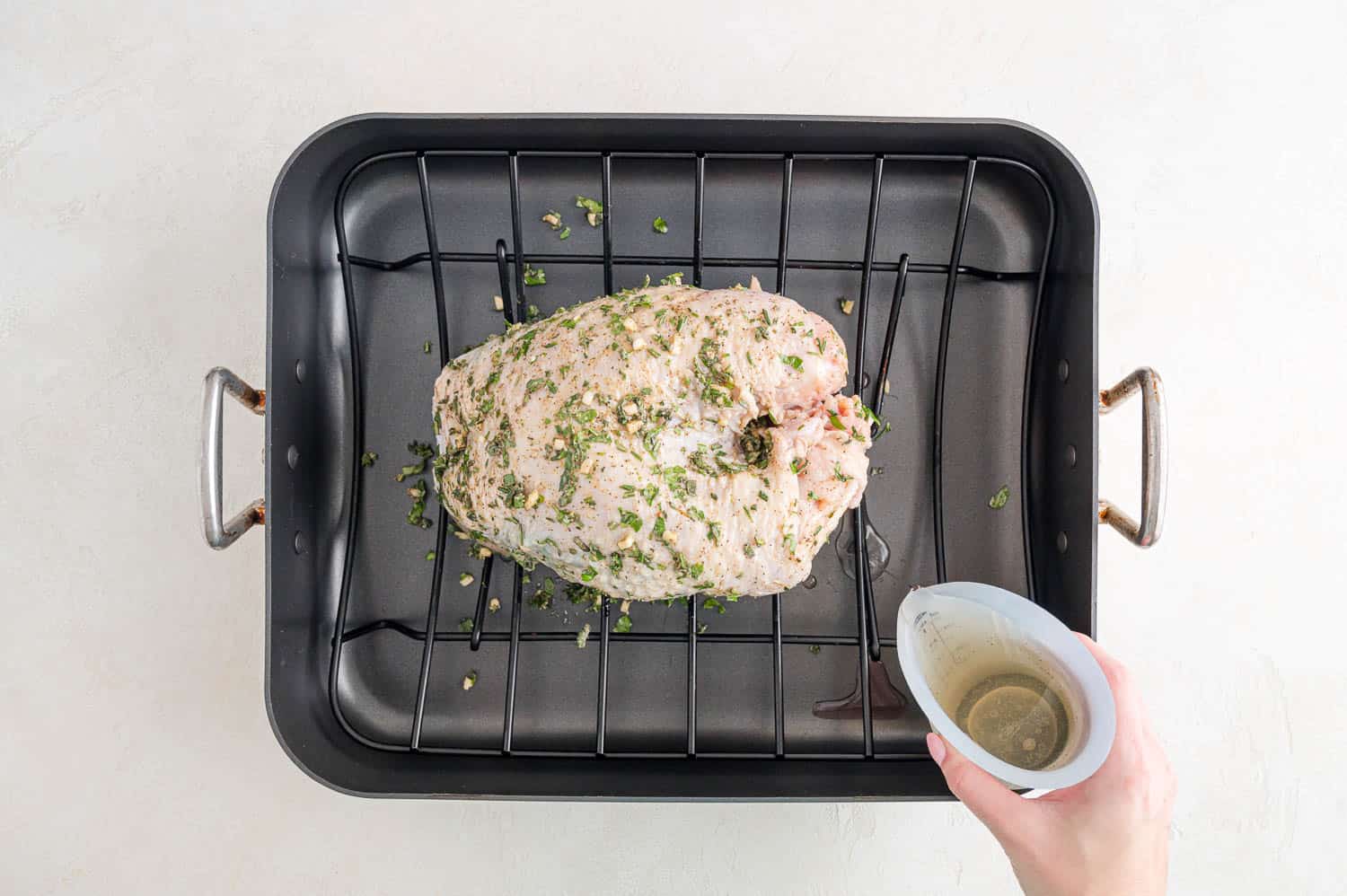 Wine being added to roasting pan.