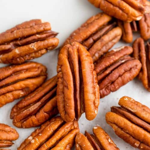 How to toasted pecans post image, pecan halves and a spatula.