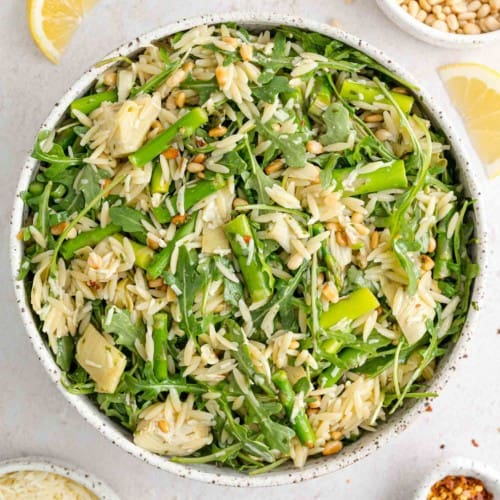 Spring orzo salad in a large white bowl.