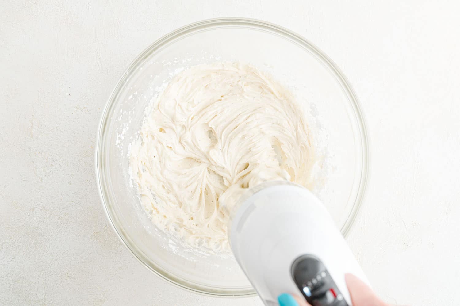 Butter and sugar being creamed together with an electric mixer.