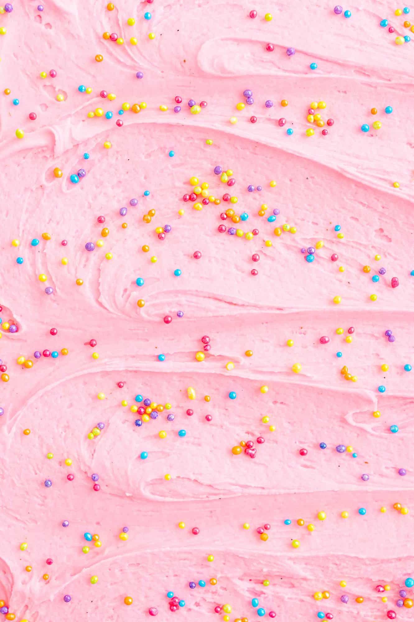 Light pink frosting with multi-colored sprinkles.
