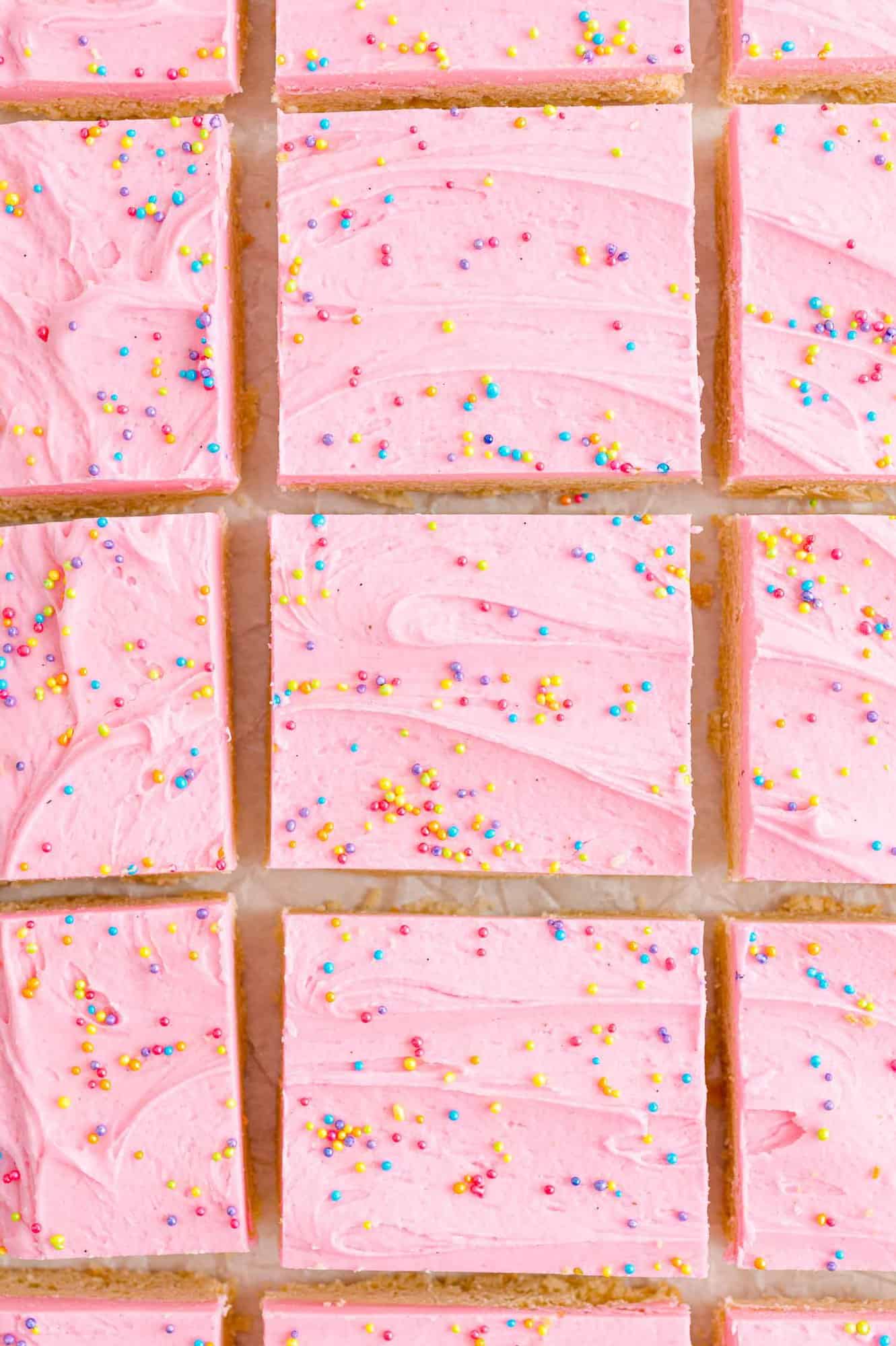 Cookie bars with pink frosting, viewed from above.