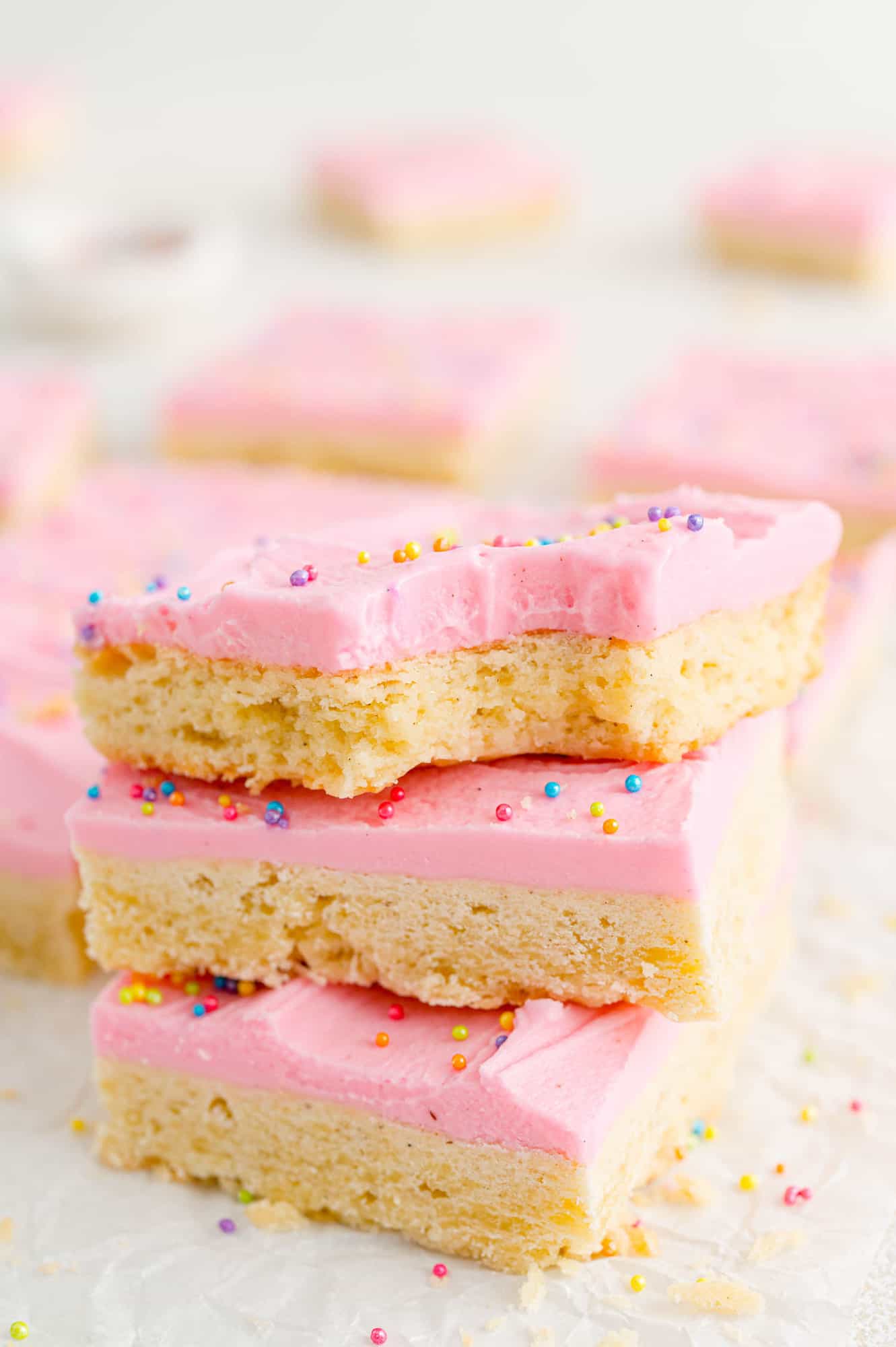 Three cookie bars with vanilla bean frosting stacked on each other.