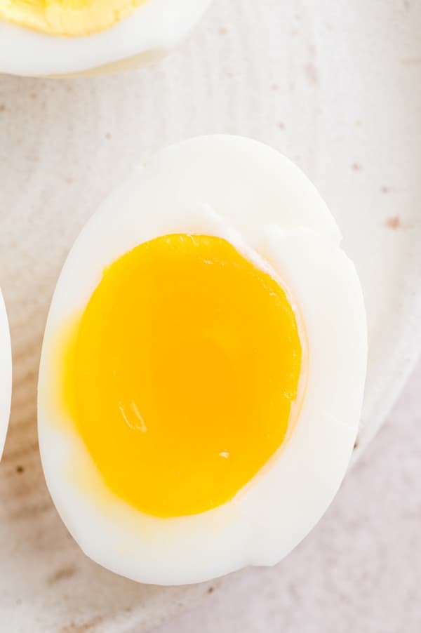 Close up of one half of a jammy boiled egg on a plate.