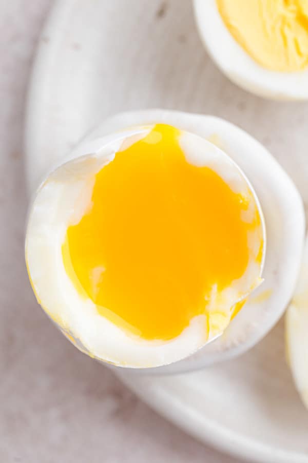 Close up of one half of a soft boiled egg on a plate.