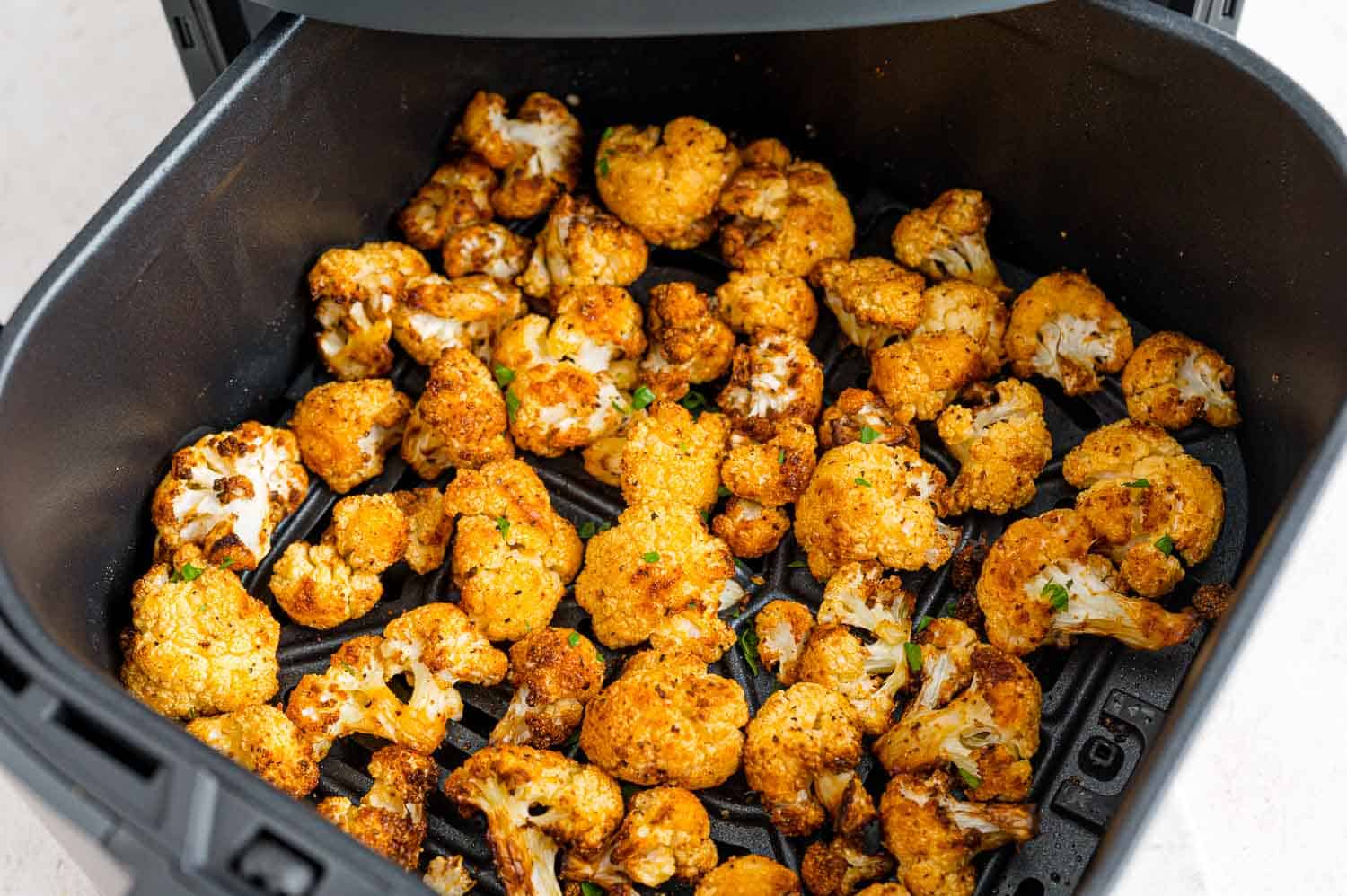 Crispy cauliflower inside the air fryer basket.