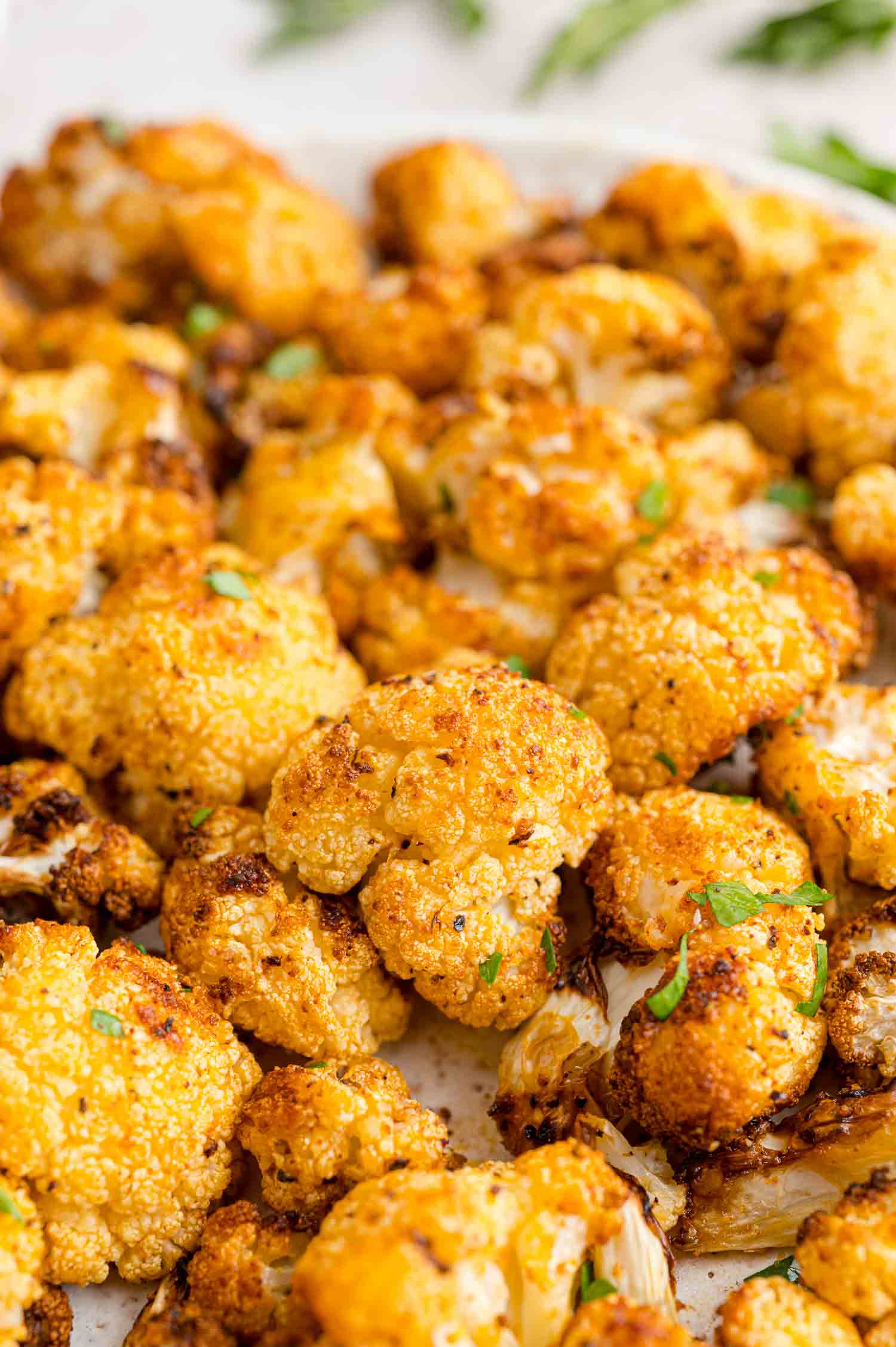 Close up of crispy air fryer cauliflower on a white plate.