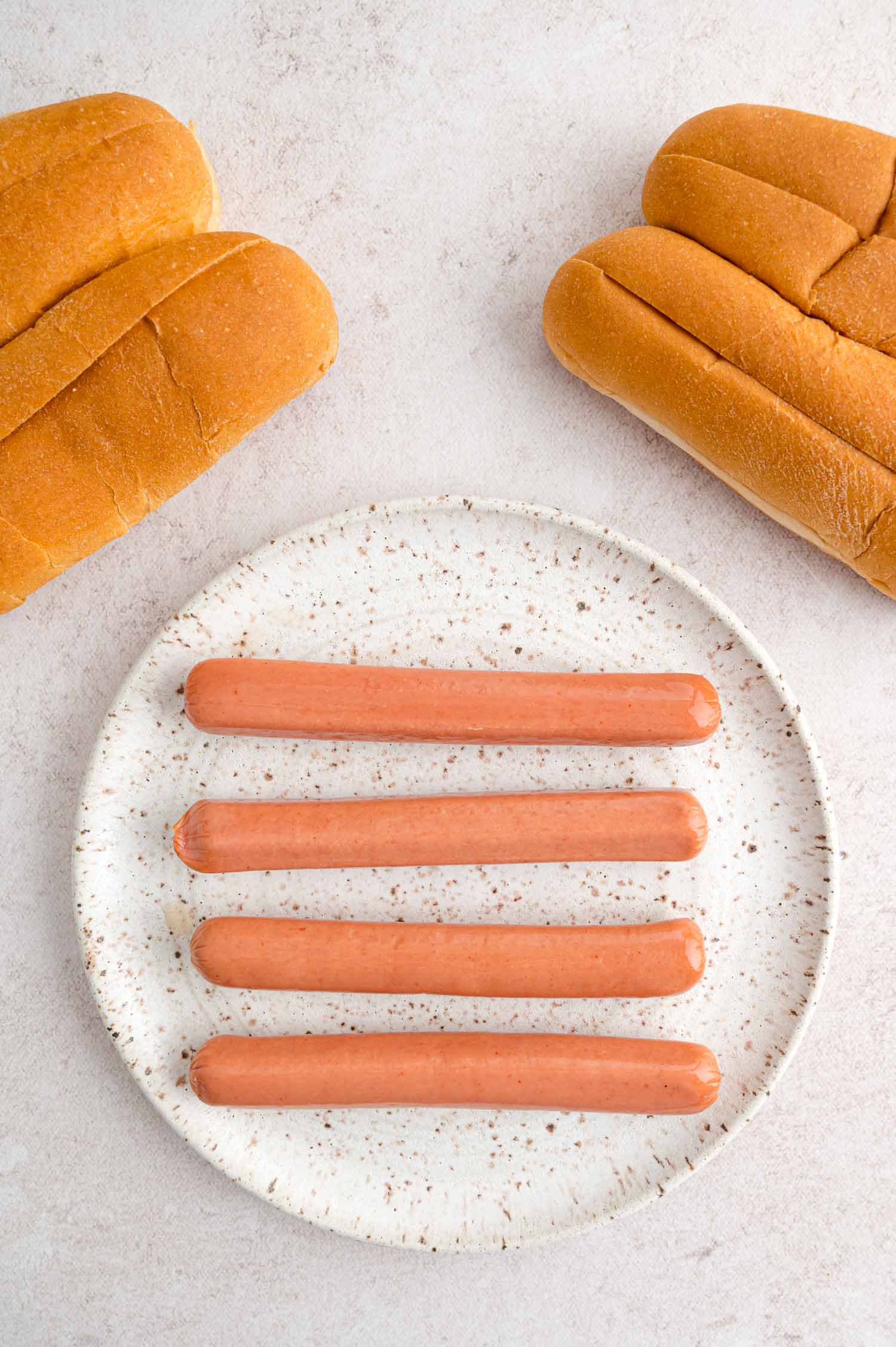 Uncooked hot dogs and buns.