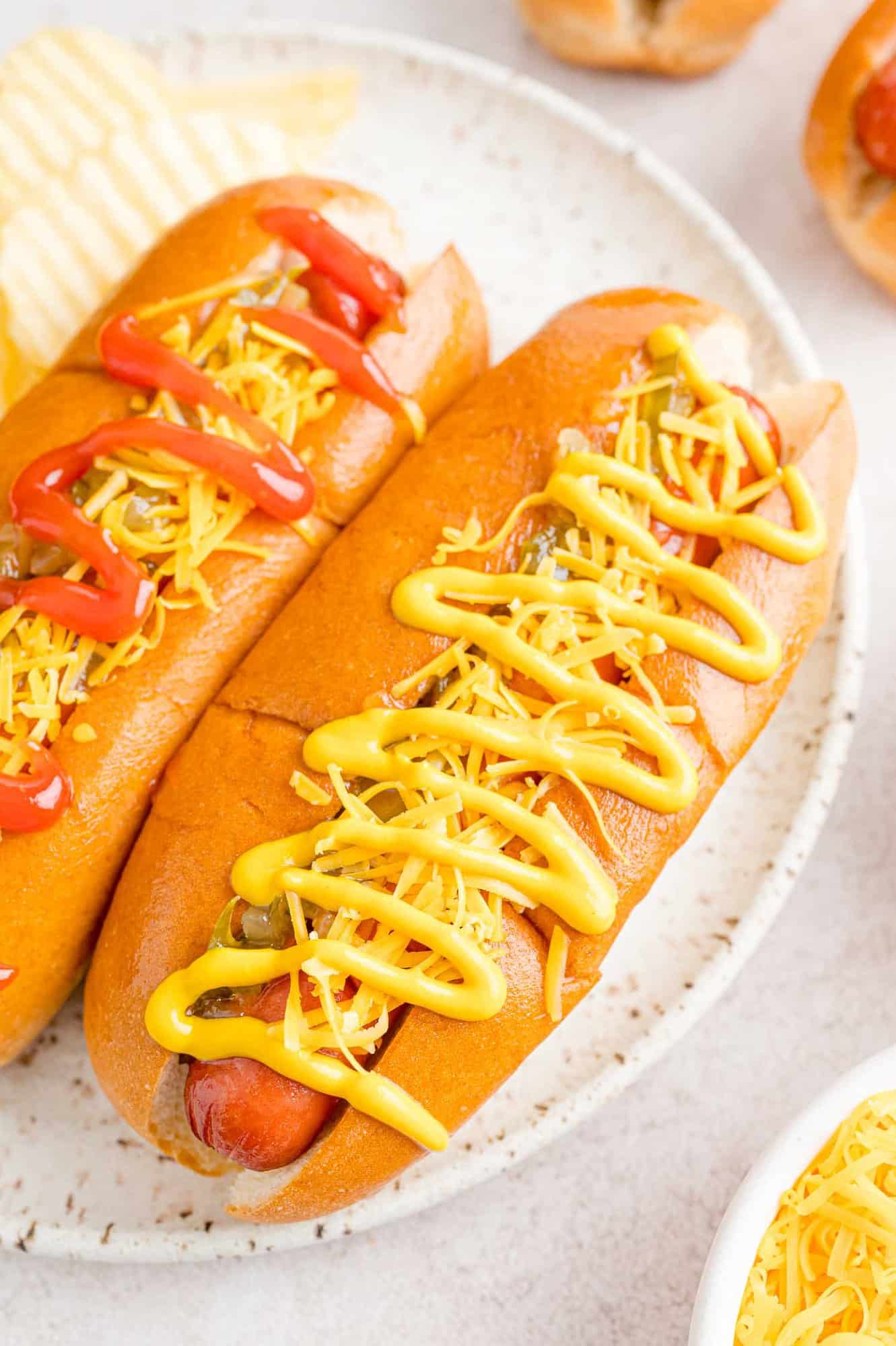 Hot dogs in buns with toppings.