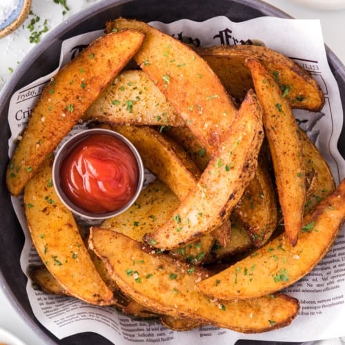 Air fryer potato wedges with ketchup.