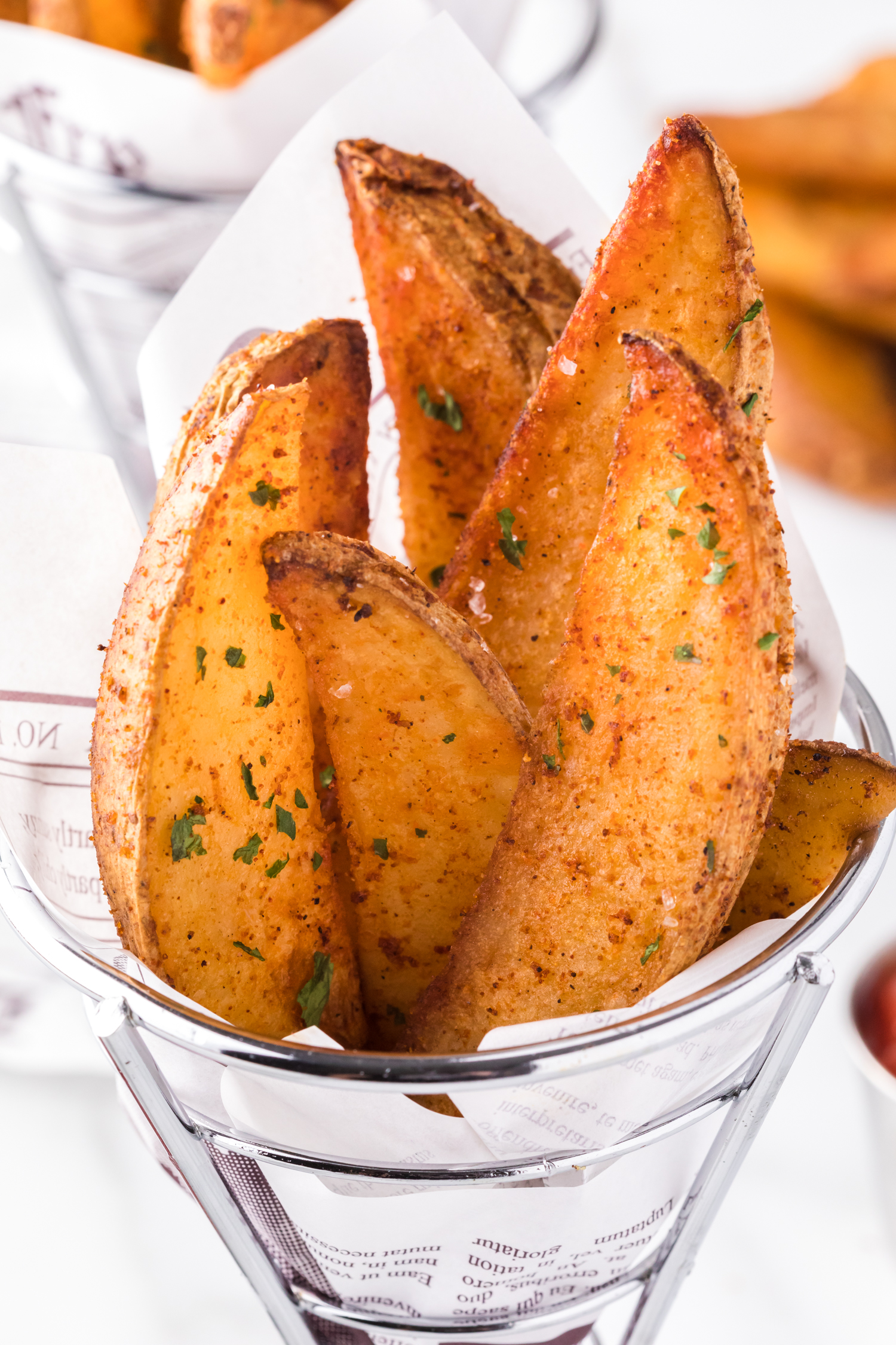 Potato wedges in a cone shaped basket.