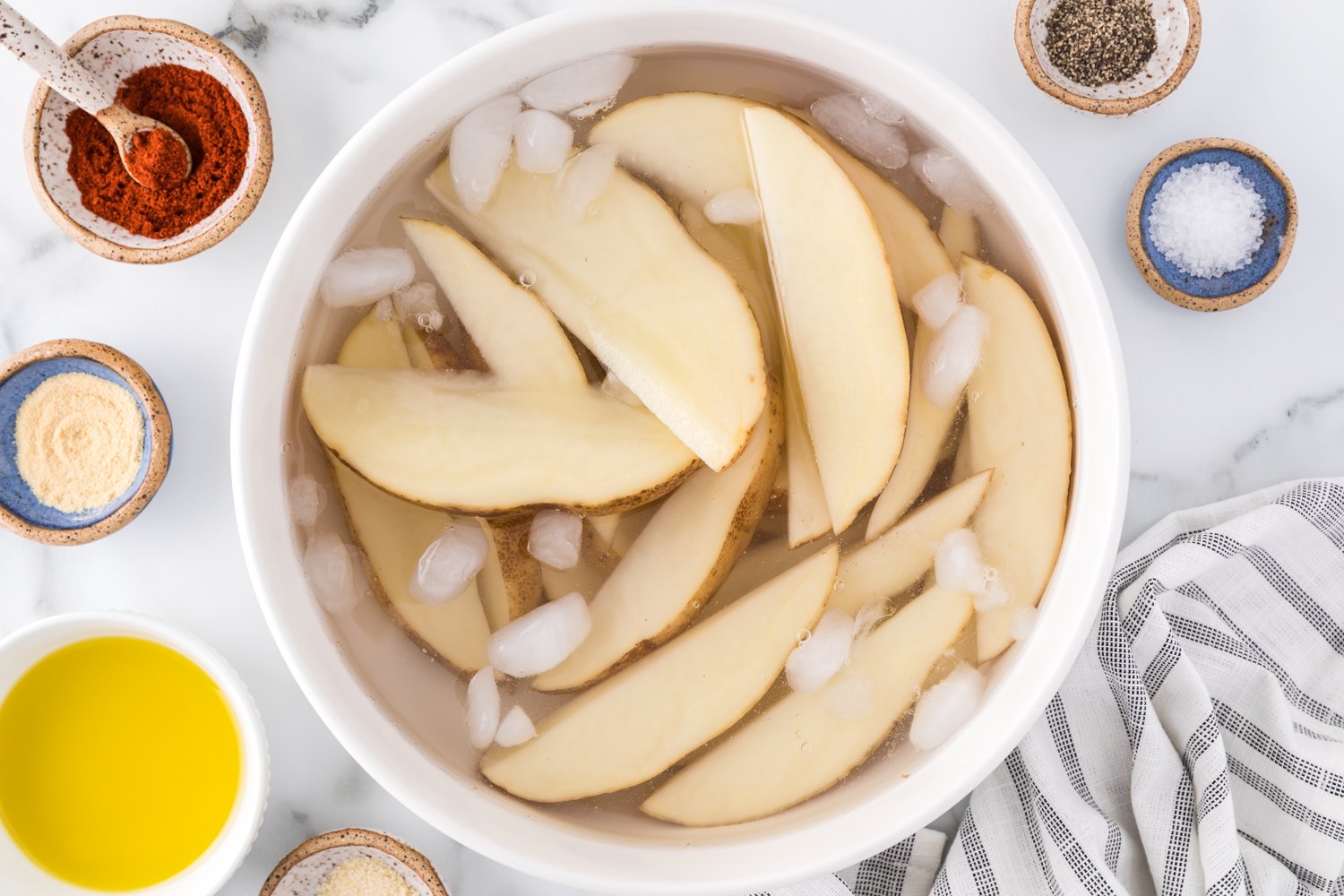 Potato wedges being soaked in water.