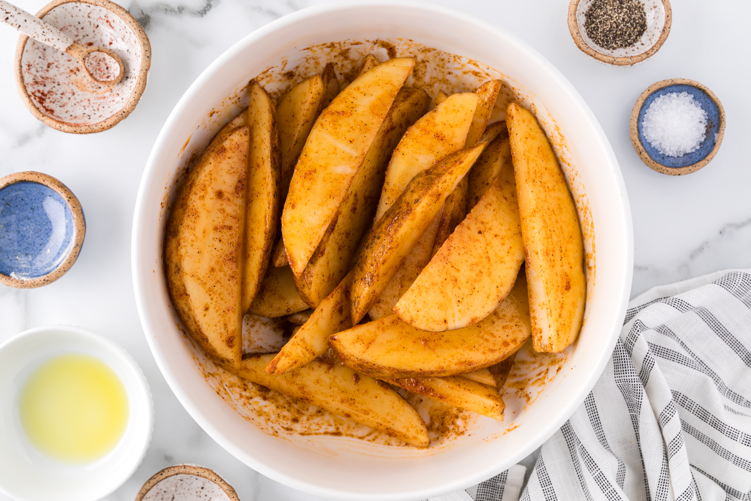 Uncooked potato wedges  mixed with oil and spices..
