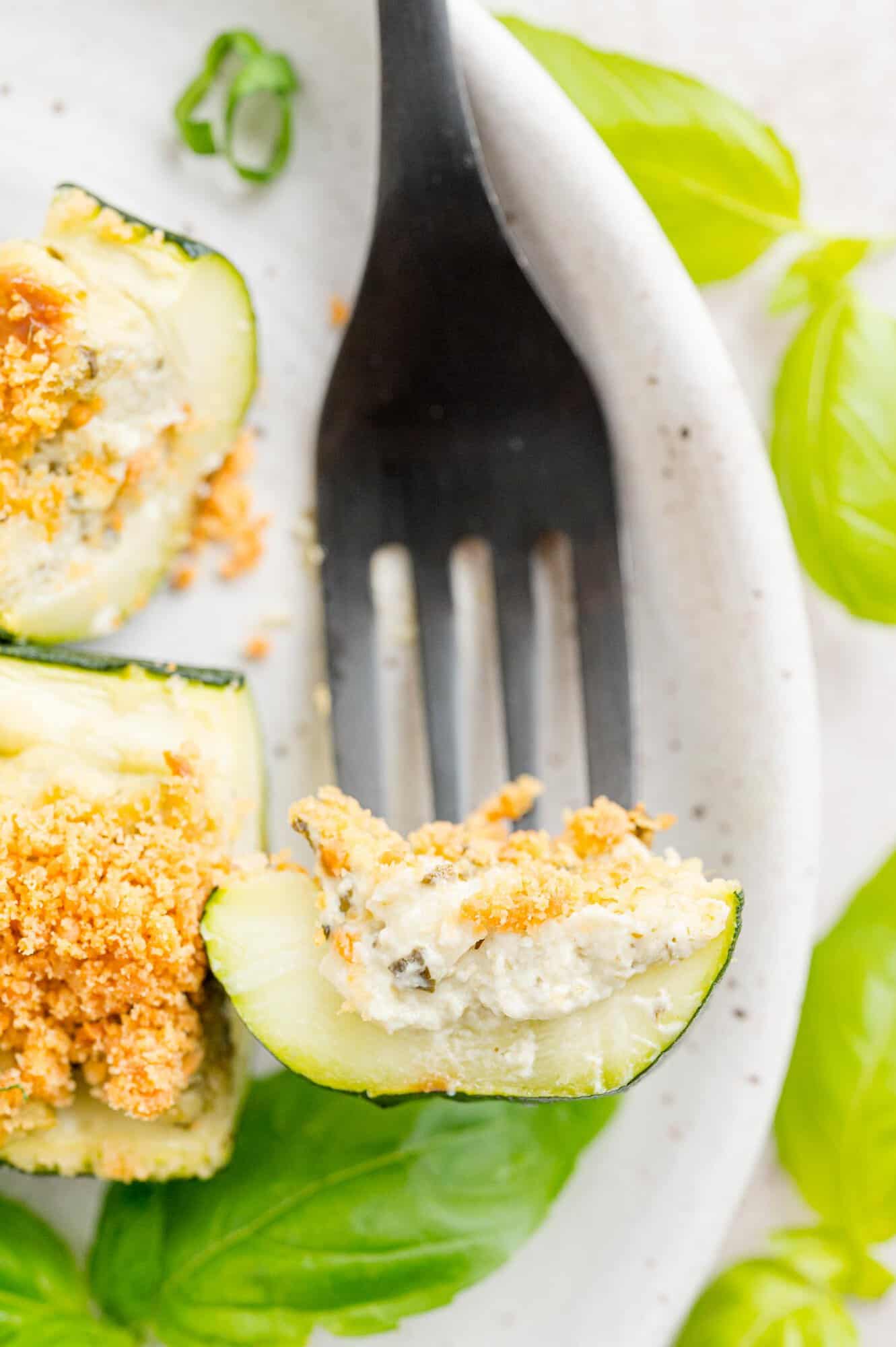 Zucchini stuffed with cheese on a fork.