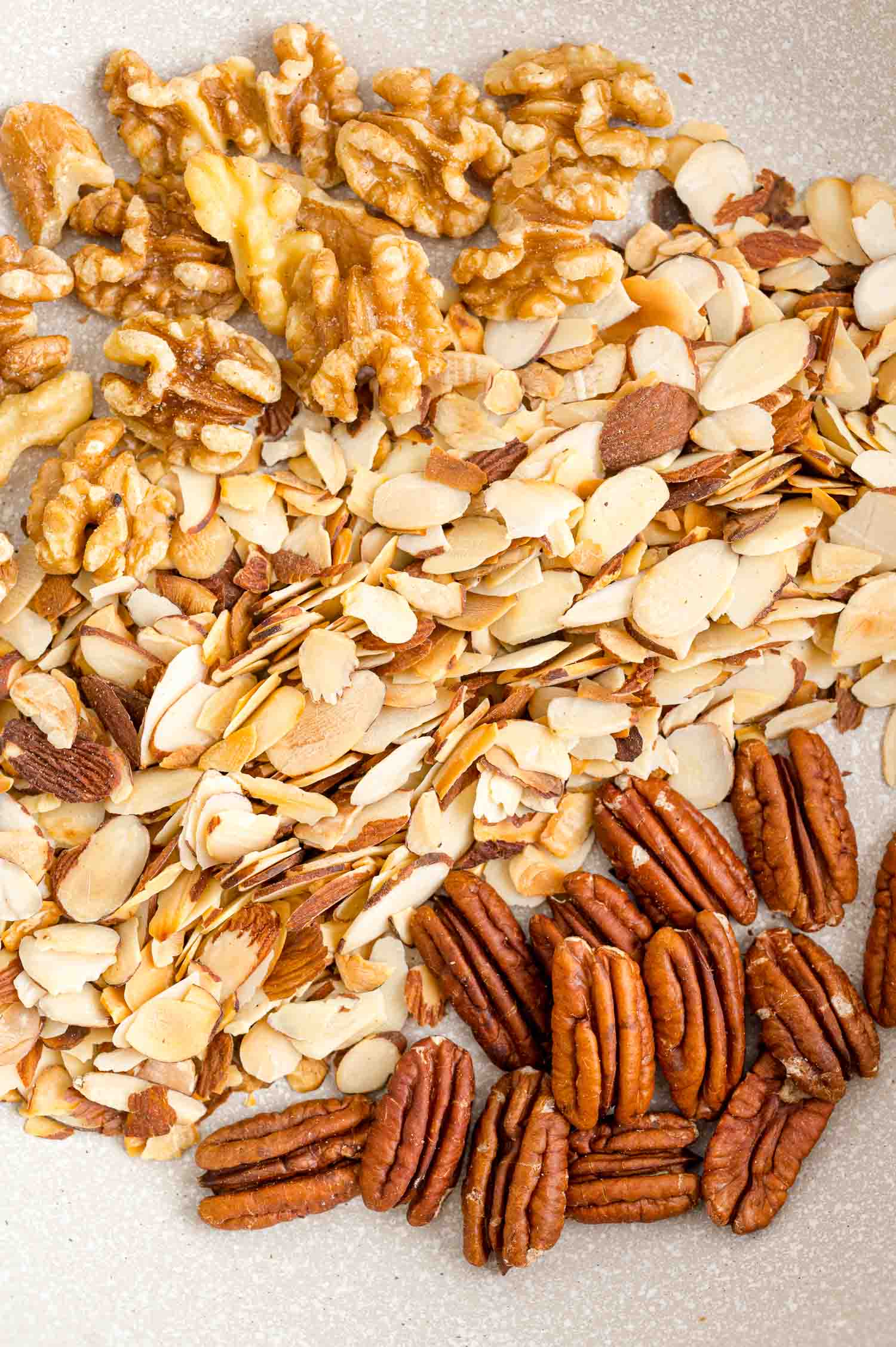 Toasted almonds, walnuts, and pecans in a bowl.