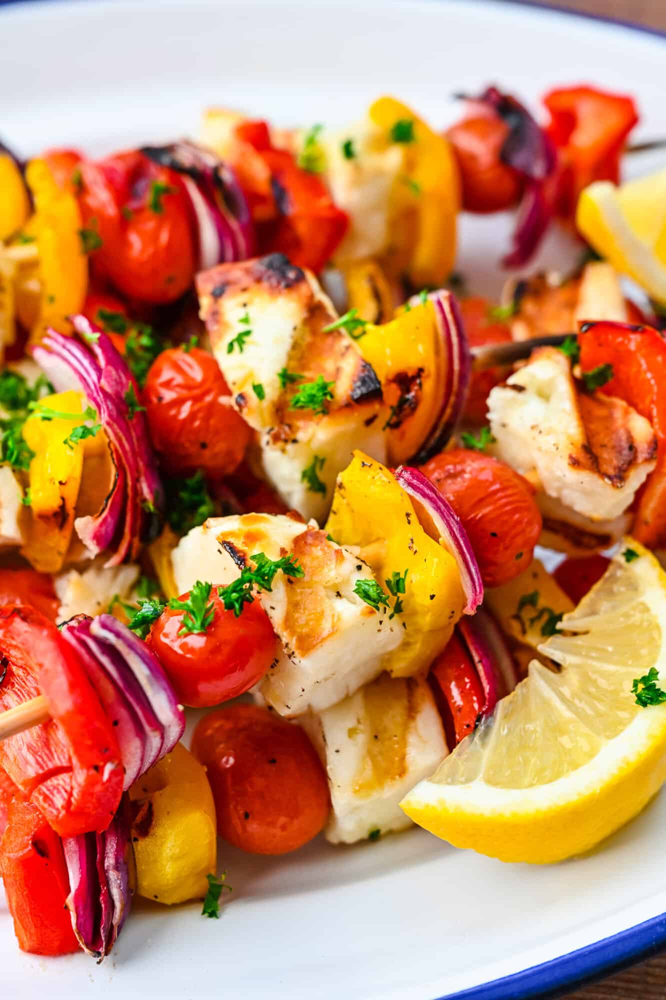 Close up of grilled kebabs with halloumi and vegetables.