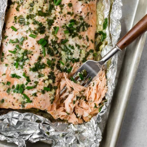 Grilled salmon in foil, topped with chives.