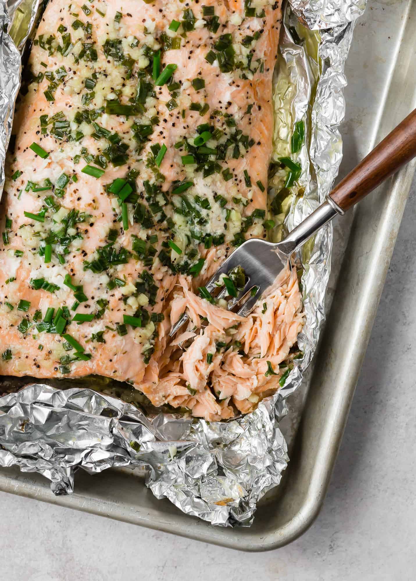 Salmon being flaked with a wooden handled fork.