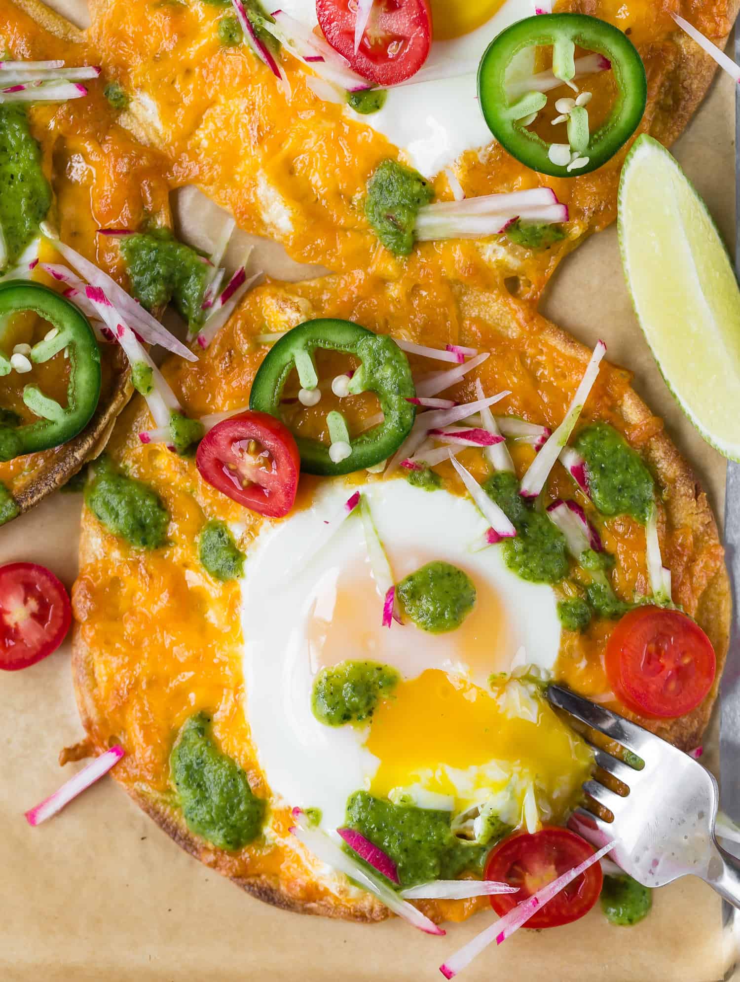 Yolk of egg on a breakfast tostada being broken.