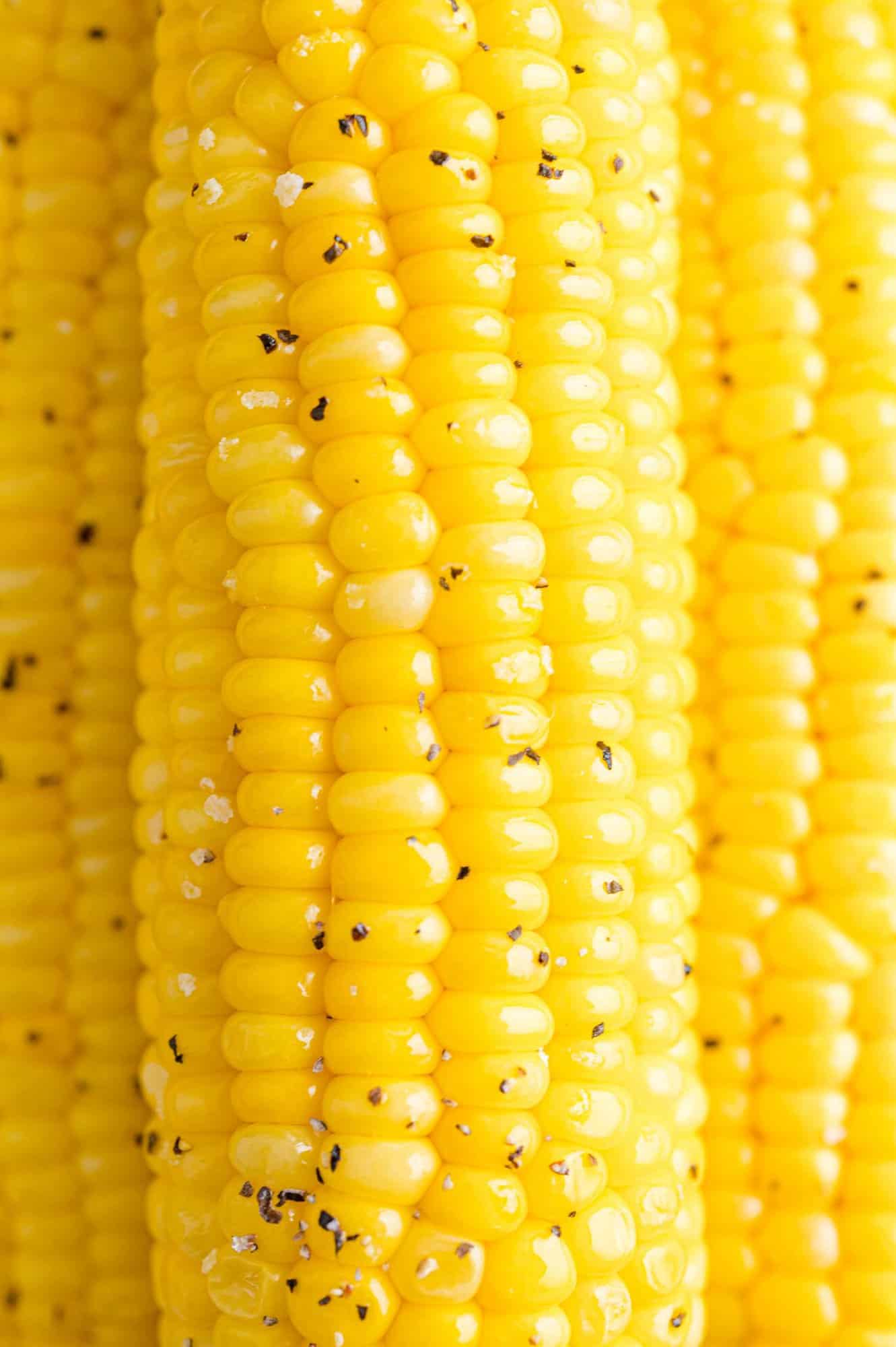 Close up of air fryer corn on the cob seasoned with salt and pepper.