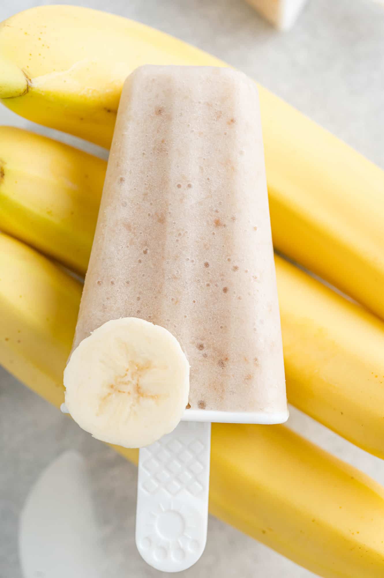 Popsicle with bananas in the background.