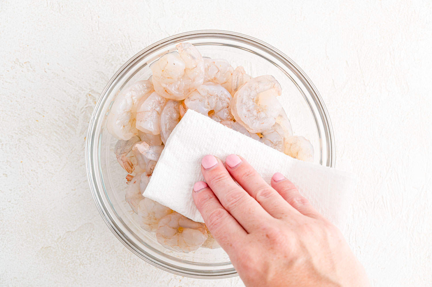 Thawed shrimp being patted dry.