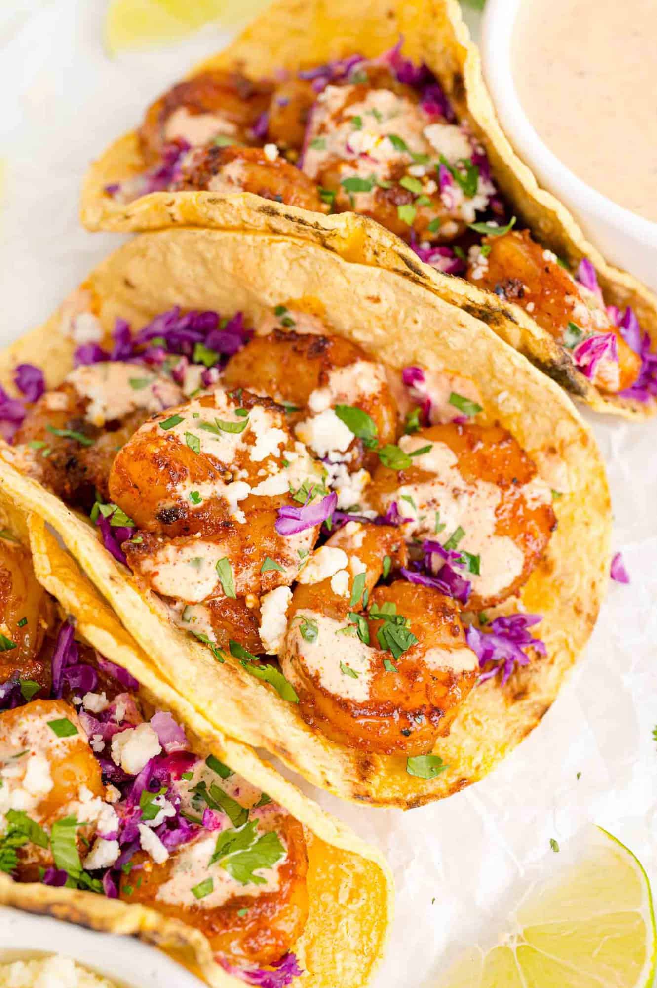 Shrimp tacos with creamy drizzle, red cabbage, cotija.
