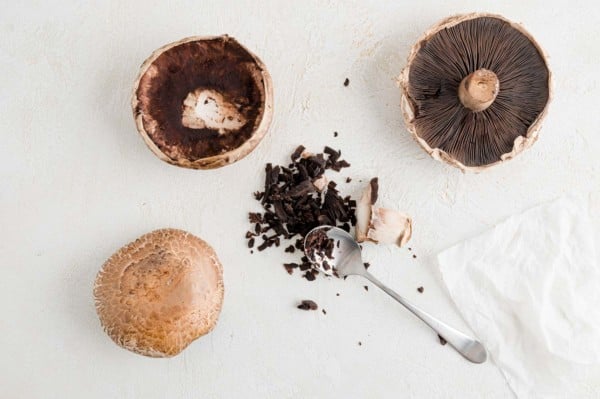 Stems being removed from mushrooms.