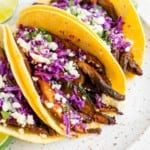 Mushroom tacos in corn tortillas with cotija cheese and cabbage.