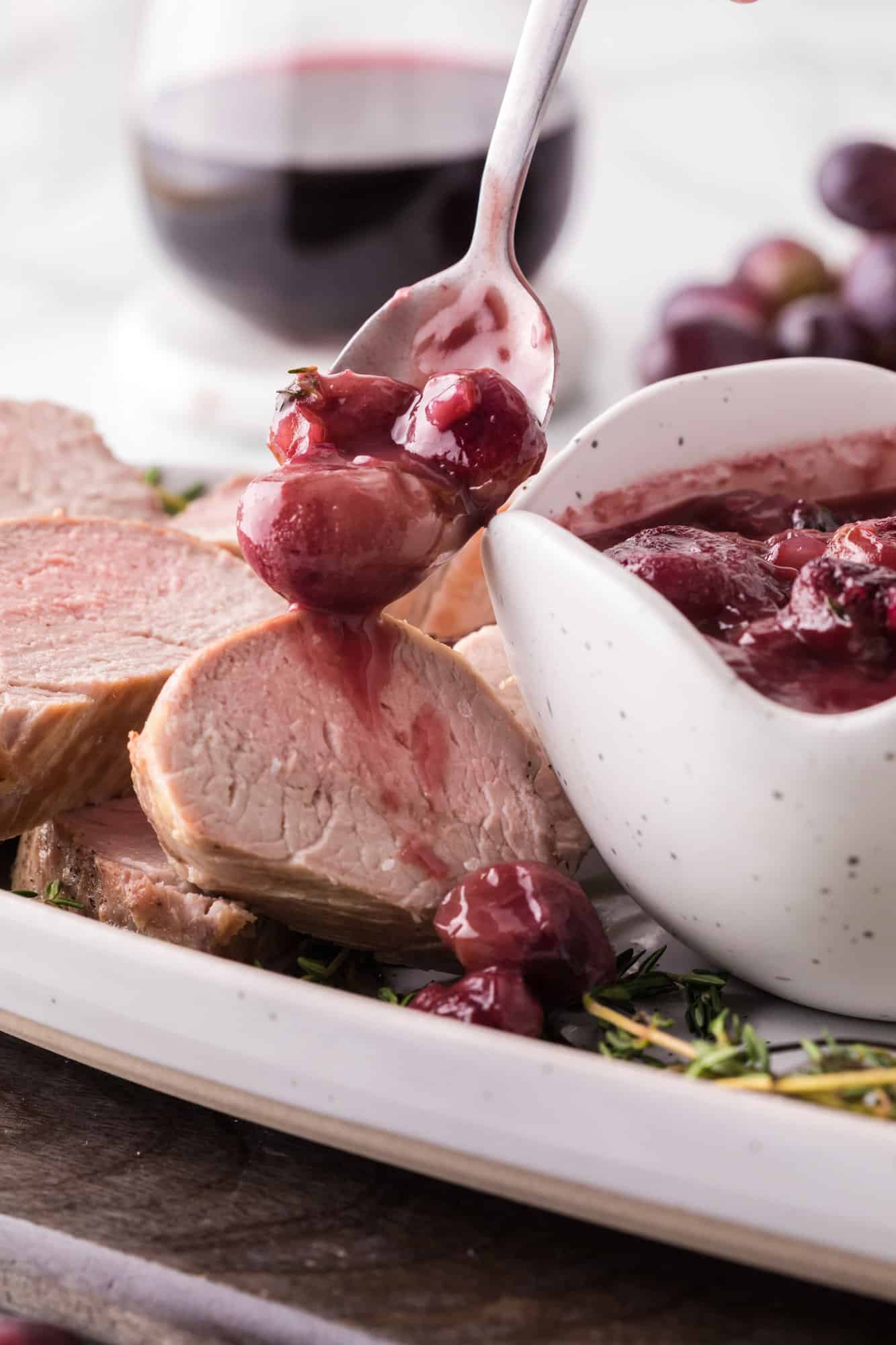 Port wine sauce being added to sliced pork tenderloin.