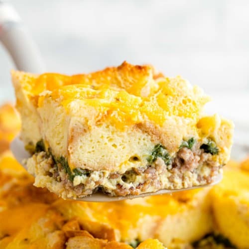 Breakfast casserole being scooped from casserole dish.