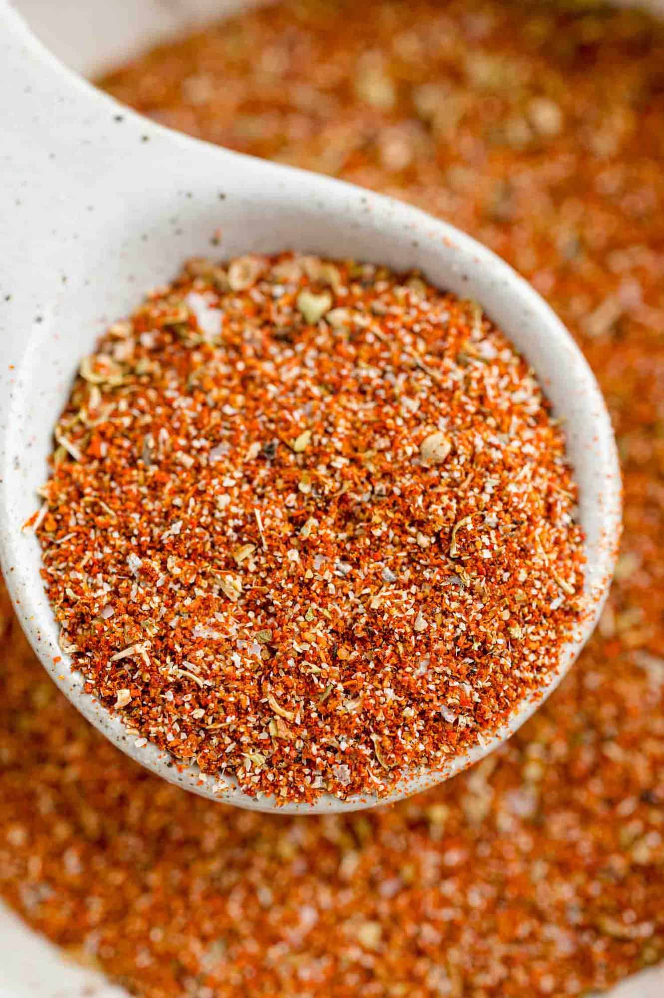 Close up of a spoonful of Southwest spice blend held over a bowl of seasoning.
