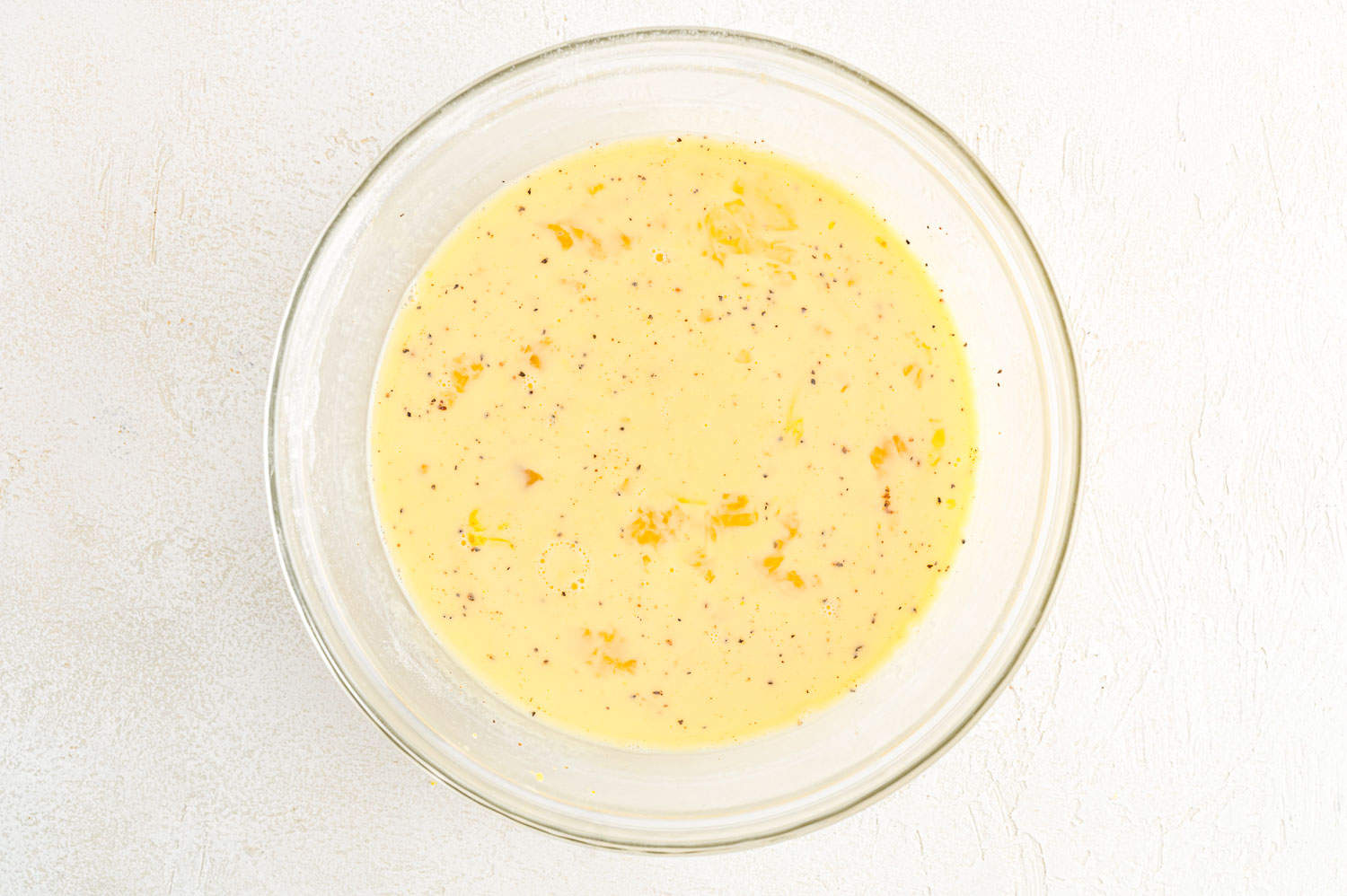 Egg mixture in a glass mixing bowl.